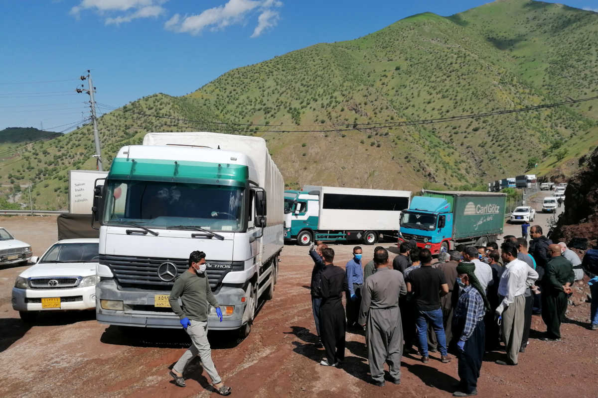 People gather near trucks after the border between Iraqi Kurdistan and Iran partially reopened for the first time since the outbreak of the coronavirus disease (COVID-19), at the border between Iran and Iraqi Kurdistan in Halabja Province, Iraq May 3, 2020. REUTERS
