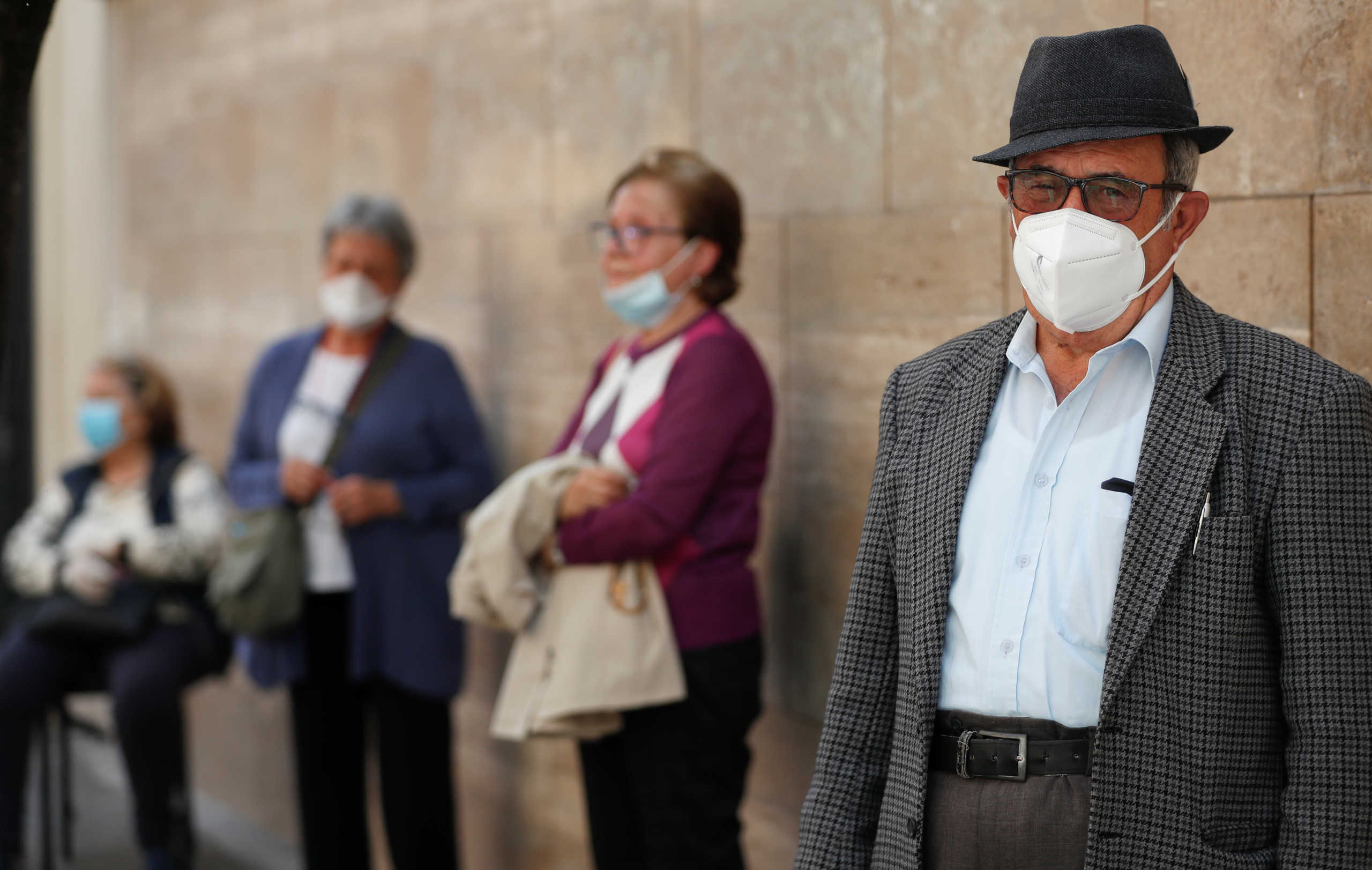 People wearing protective face masks attend the rosary prayer on a street ahead of Masses being allowed to resume inside churches from May 18 due to the spread of the coronavirus disease (COVID-19), in Rome, Italy May 14, 2020. REUTERS