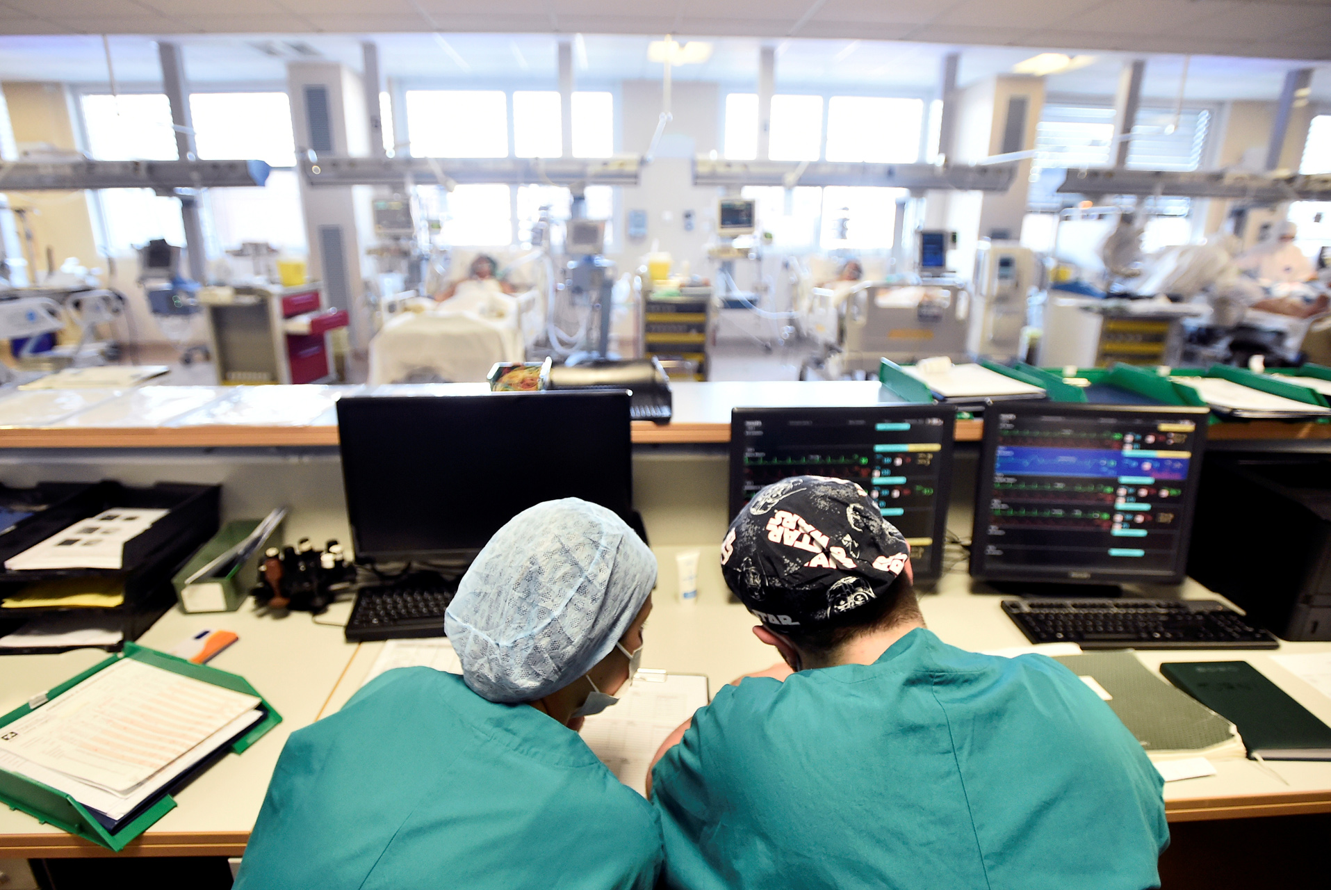 Medical staff members are seen behind a desk in the intensive care unit, where patients suffering from the coronavirus disease (COVID-19) are treated, at the Circolo hospital in Varese, Italy April 9, 2020. REUTERS