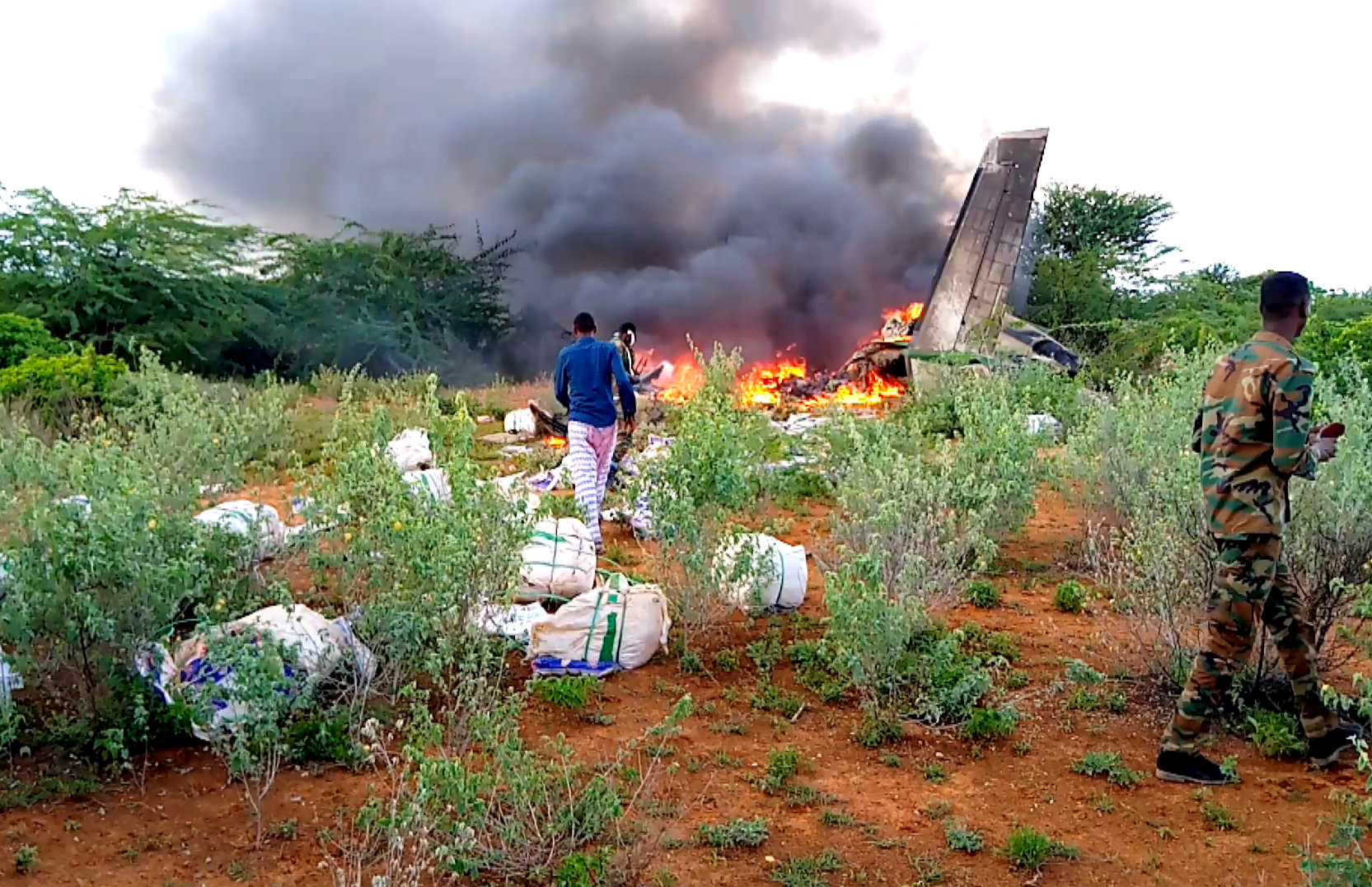 A general view shows unidentified security personnel at the crash site of a private cargo plane belonging to African Express Airways that was ferrying supplies for use in the fight against the coronavirus disease (COVID-19) when it crashed in the town of Bardale, southern Bay region, Somalia May 4, 2020. Picture taken May 4, 2020. REUTERS