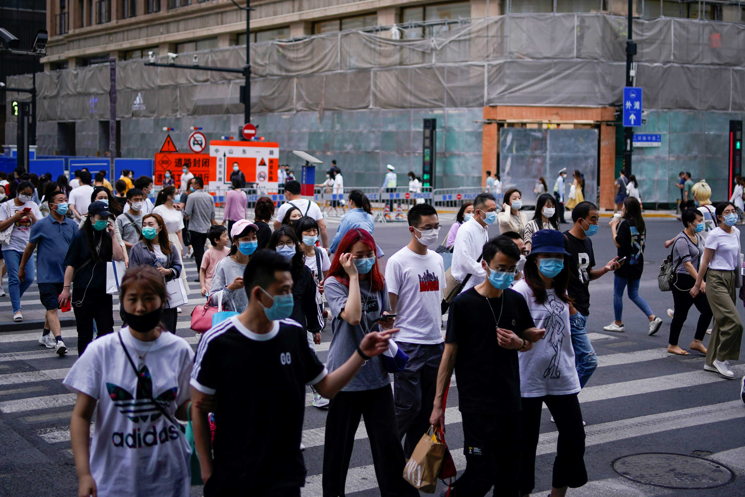 People wearing protective face masks are seen on a street following an outbreak of the novel coronavirus disease (COVID-19), in Shanghai, China May 25, 2020. REUTERS