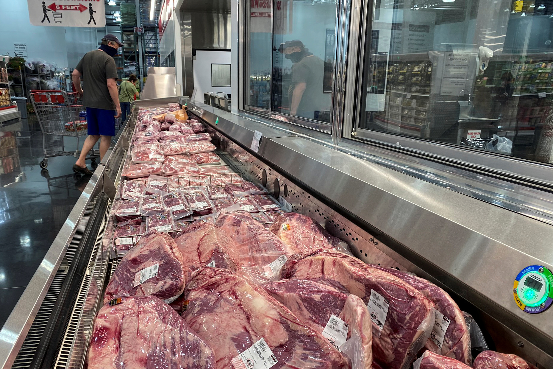 A man sporting a face mask looks toward pork in the meat section of a Costco warehouse club during the coronavirus disease (COVID-19) pandemic in Webster, Texas, U.S., May 5, 2020. REUTERS