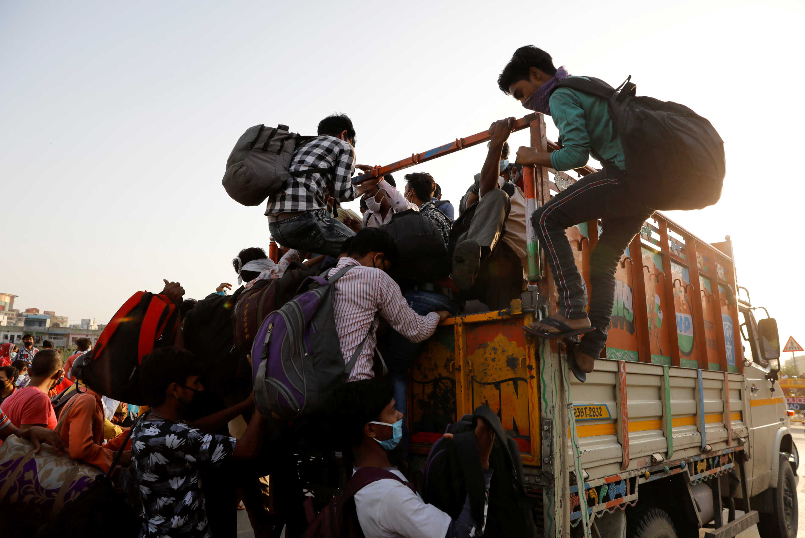 Migrants rush to get inside a Tempo that will drive them across the border, during an extended nationwide lockdown to slow the spread of the coronavirus disease (COVID-19), in New Delhi, India, May 15, 2020. REUTERS