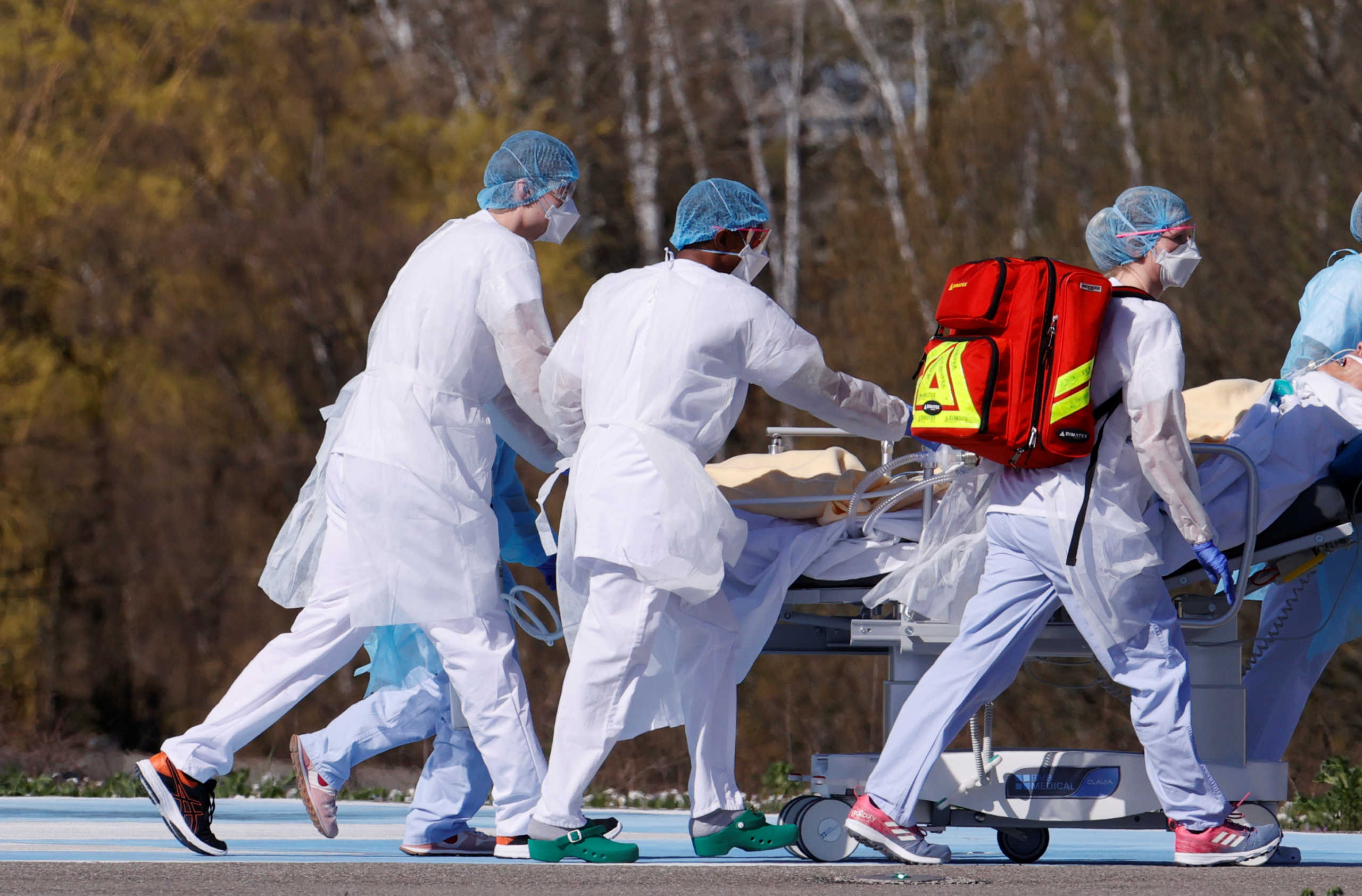 French rescue team wearing protective suits carry a patient on a stretcher from Mulhouse hospital before being loaded into a helicopter as France faces an aggressive progression of the coronavirus disease (COVID-19), March 23, 2020. Picture taken March 23, 2020. REUTERS