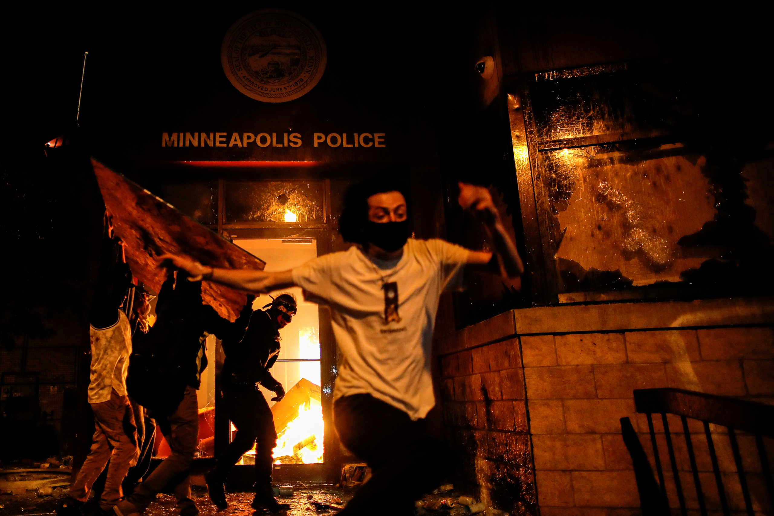 Protesters react as they set fire to the entrance of a police station as demonstrations continue after a white police officer was caught on a bystander's video pressing his knee into the neck of African-American man George Floyd, who later died at a hospital, in Minneapolis, Minnesota, U.S., May 28, 2020. REUTERS