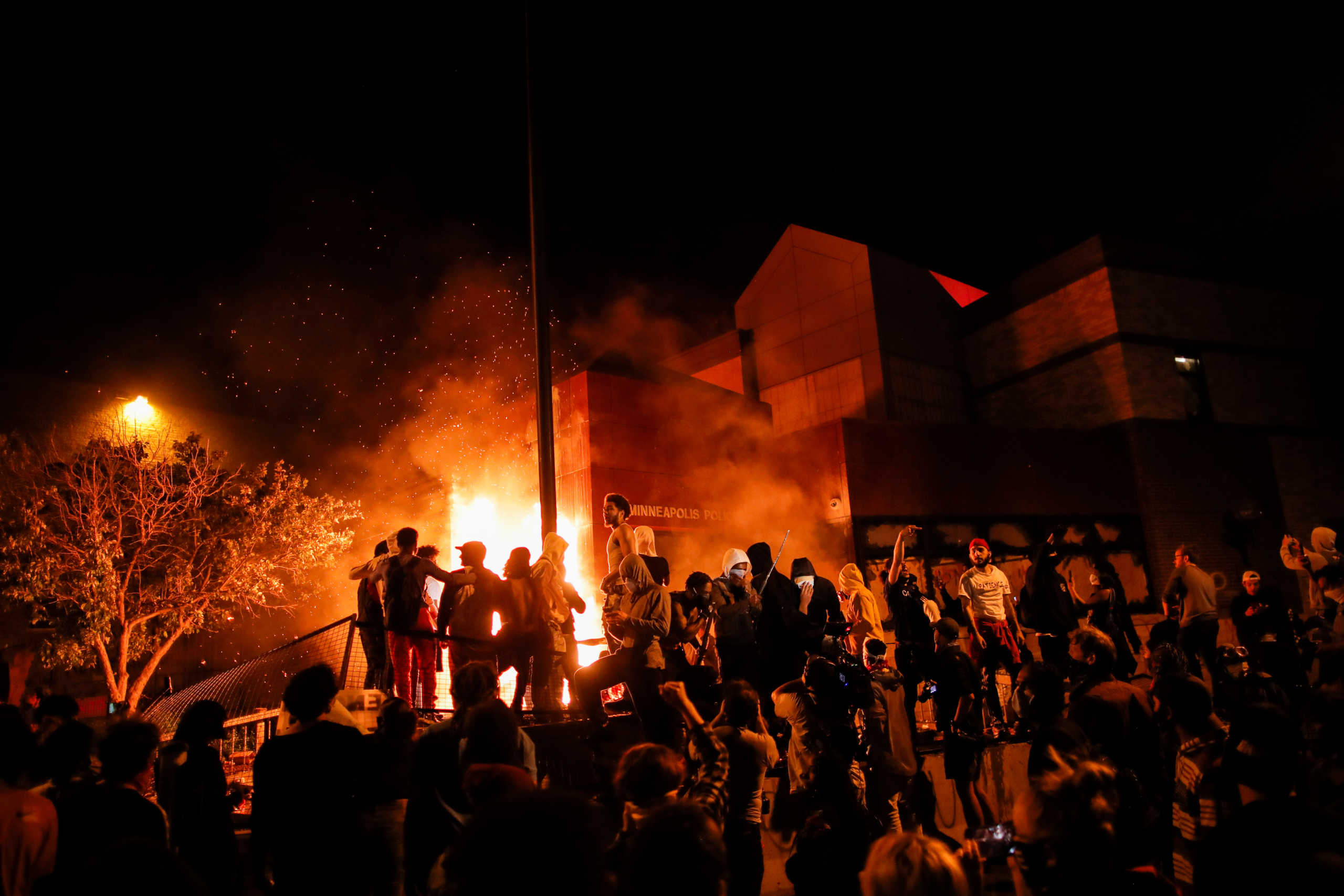 Protesters gather around after setting fire to the entrance of a police station as demonstrations continue after a white police officer was caught on a bystander's video pressing his knee into the neck of African-American man George Floyd, who later died at a hospital, in Minneapolis, Minnesota, U.S., May 28, 2020. REUTERS