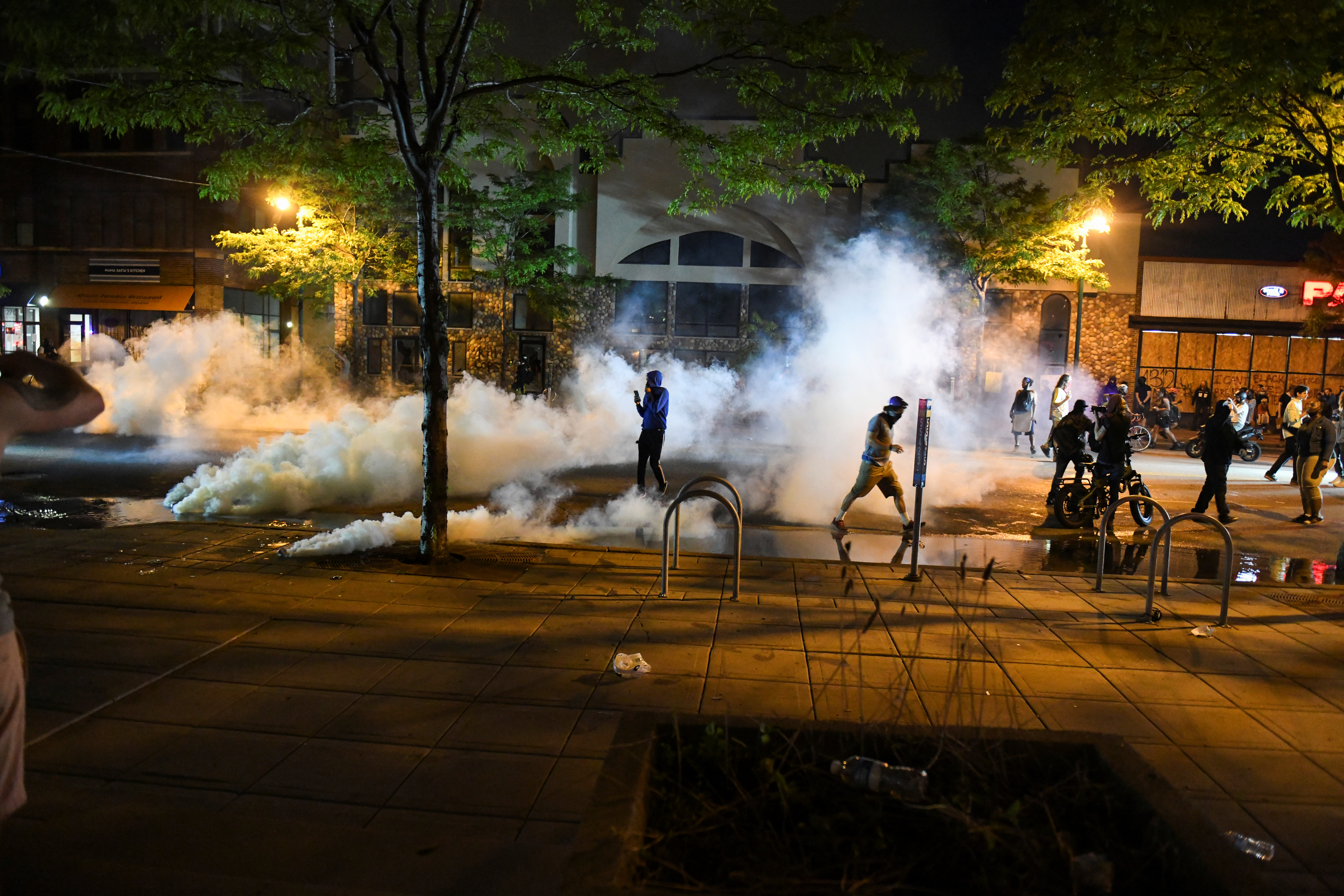 Protesters run from tear gas near the Minneapolis Police third precinct, where they gathered after a white police officer was caught on a bystander's video pressing his knee into the neck of African-American man George Floyd, who later died at a hospital, in Minneapolis, Minnesota, U.S. May 27, 2020. REUTERS