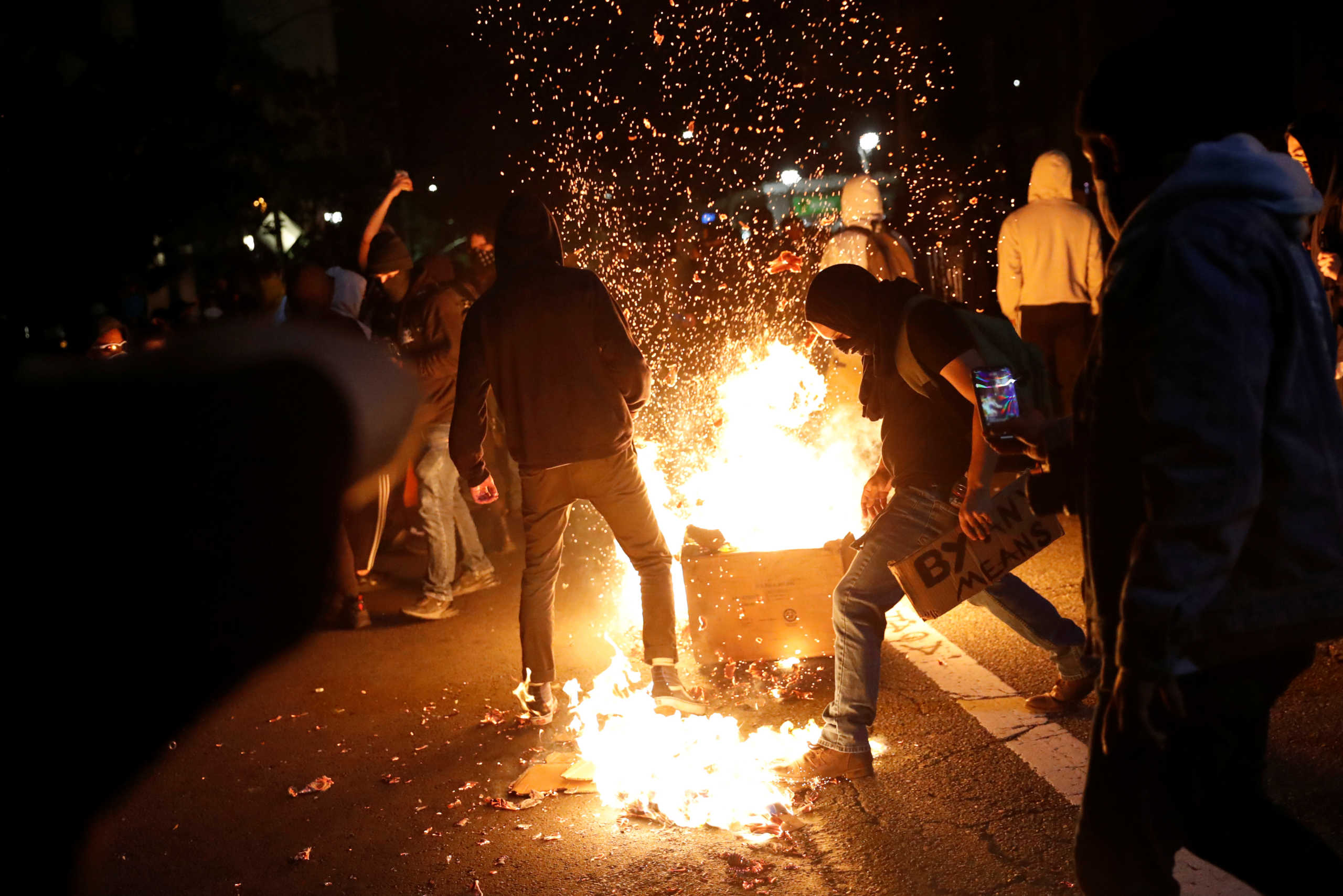Demonstrators attempt to extinguish a trash fire during a protest against the death of African-American man George Floyd under Minneapolis police custody, in Oakland, California, U.S. May 29, 2020. REUTERS