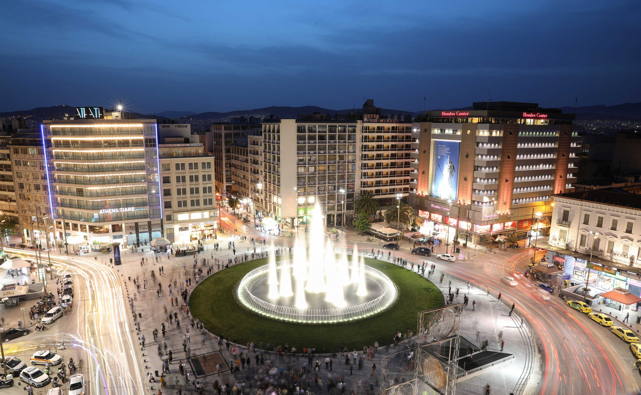 People gather around the fountain of the newly renovated Omonia square, in Athens, Greece, May 14, 2020. Picture taken with long exposure. REUTERS