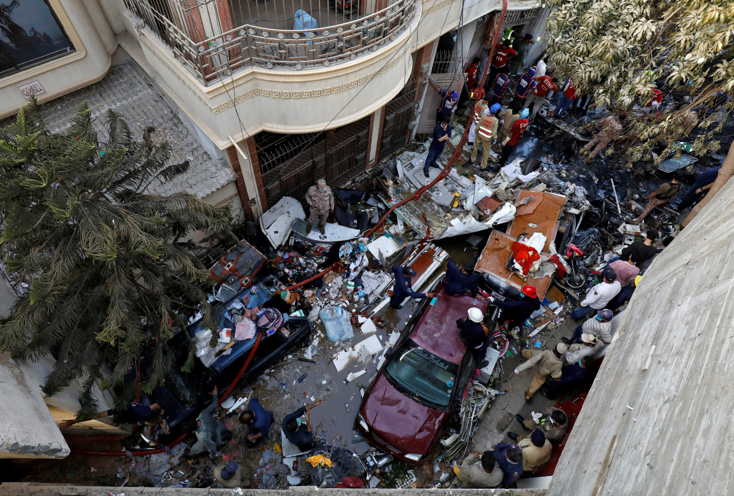 Rescue workers gather at the site of a passenger plane crash in a residential area near an airport in Karachi, Pakistan May 22, 2020. REUTERS