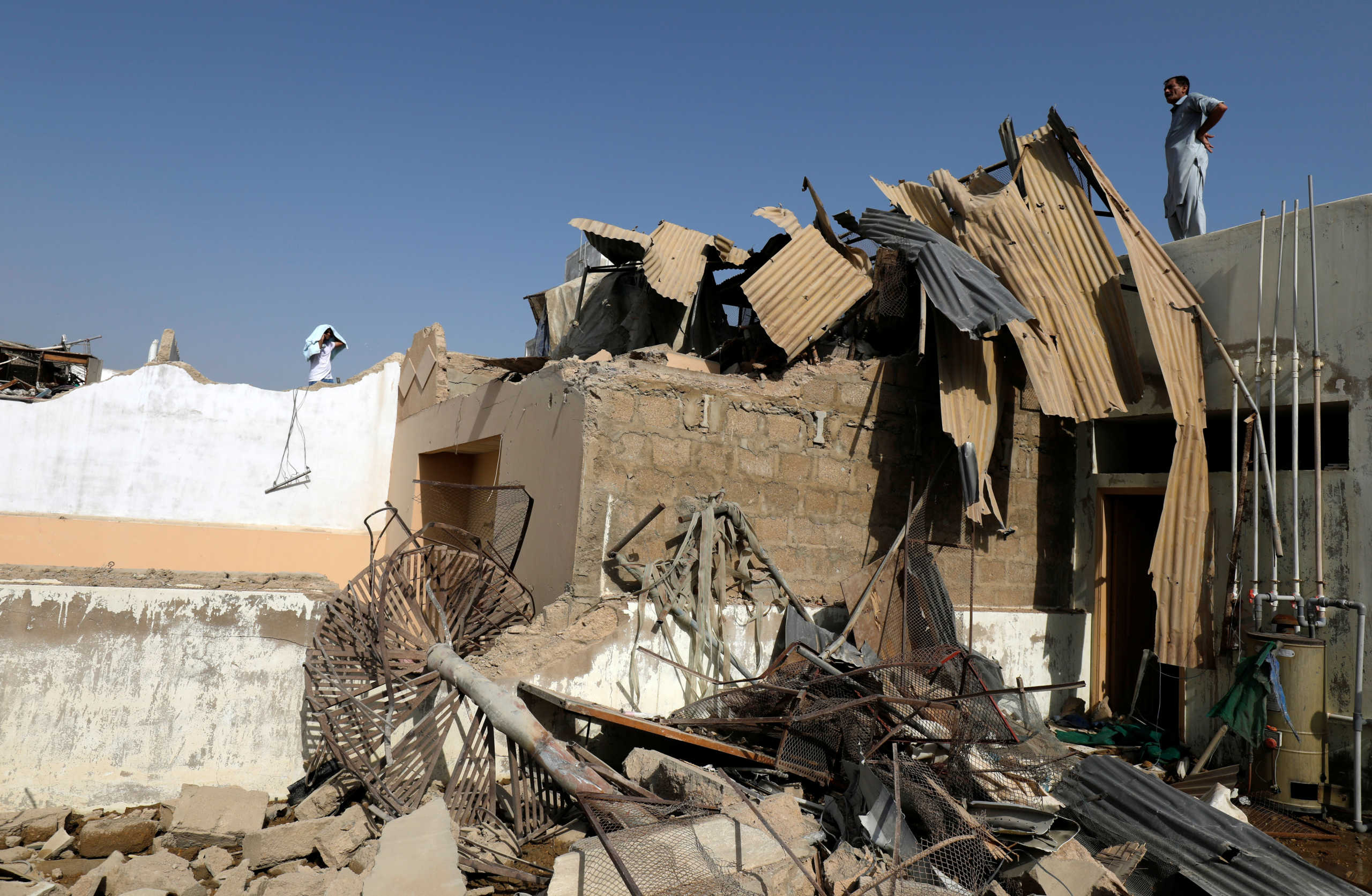 A man stands near the debris of a house at the site of a passenger plane crash in a residential area near an airport in Karachi, Pakistan May 22, 2020. REUTERS