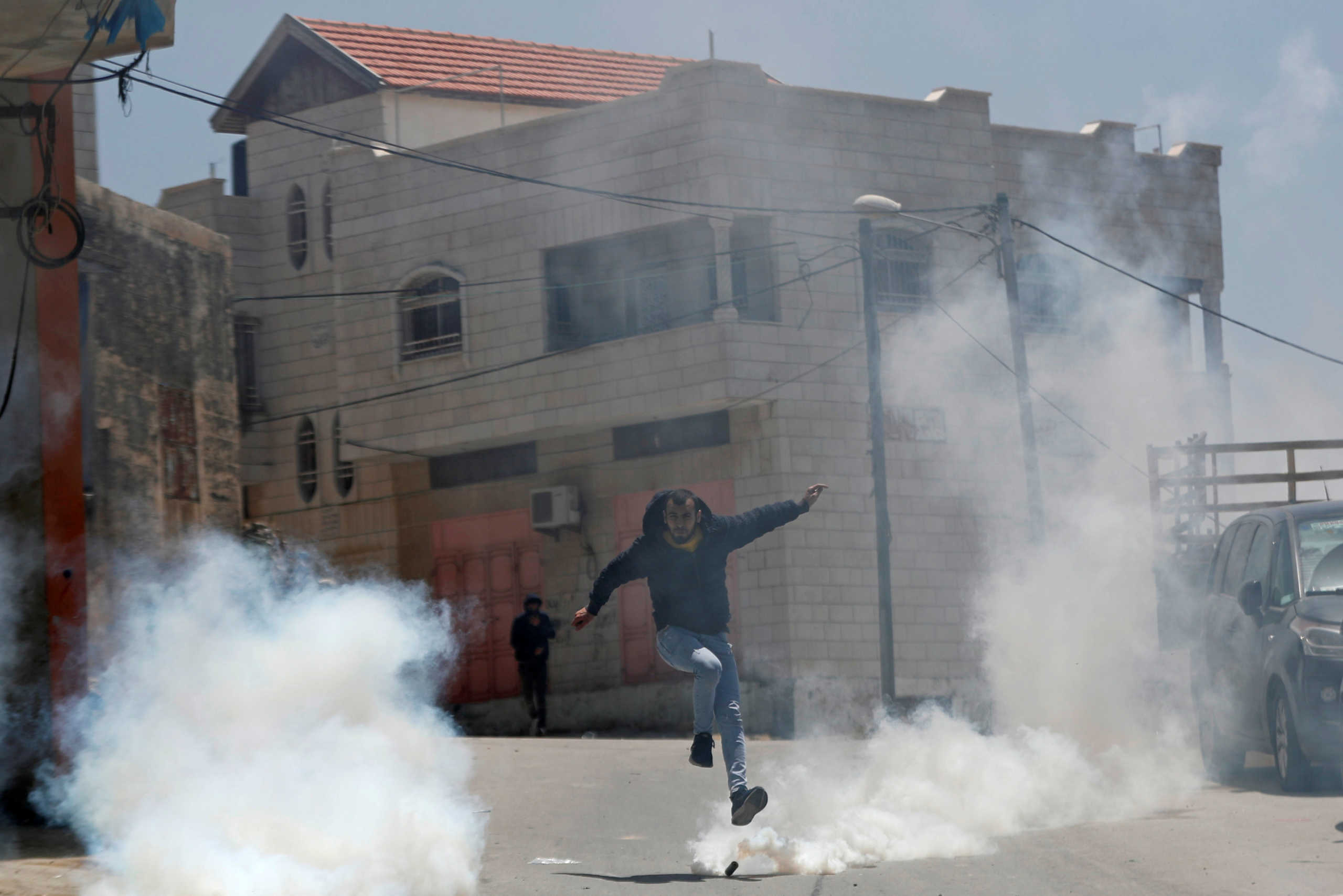 A Palestinian runs away from tear gas fired by Israeli forces during a raid after an Israeli soldier was killed by a rock, in Yabad near Jenin in the Israeli-occupied West Bank May 12, 2020. REUTERS