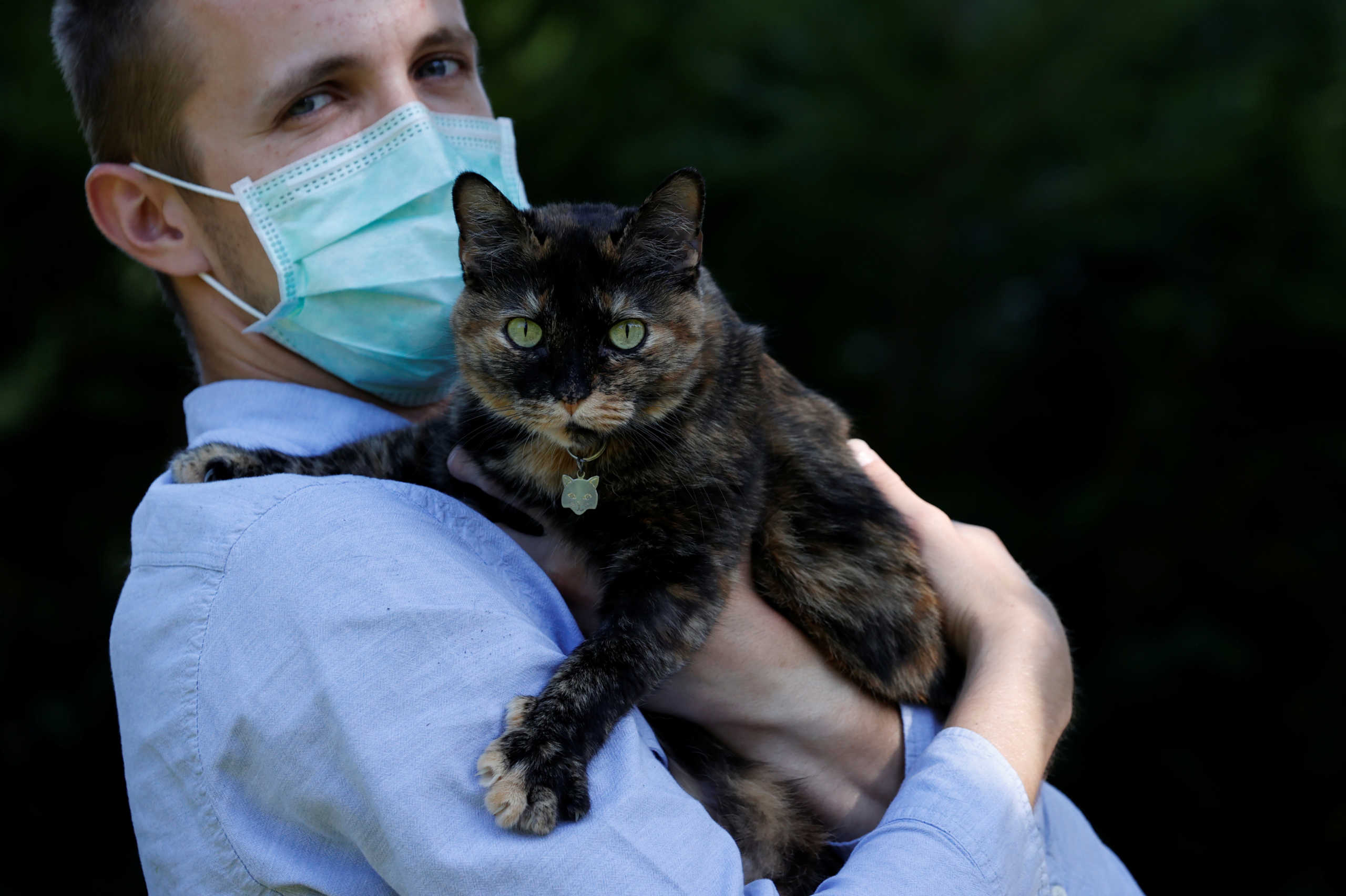 Brian, 24 year-old, suspected to have been infected by the SARS-CoV-2 poses in his garden with Papille, his 9 year-old cat who recovered after being tested positive for the virus amid the coronavirus disease (COVID-19) outbreak, in Athis-Mons, near Paris, France, May 27, 2020. Picture taken May 27, 2020. REUTERS
