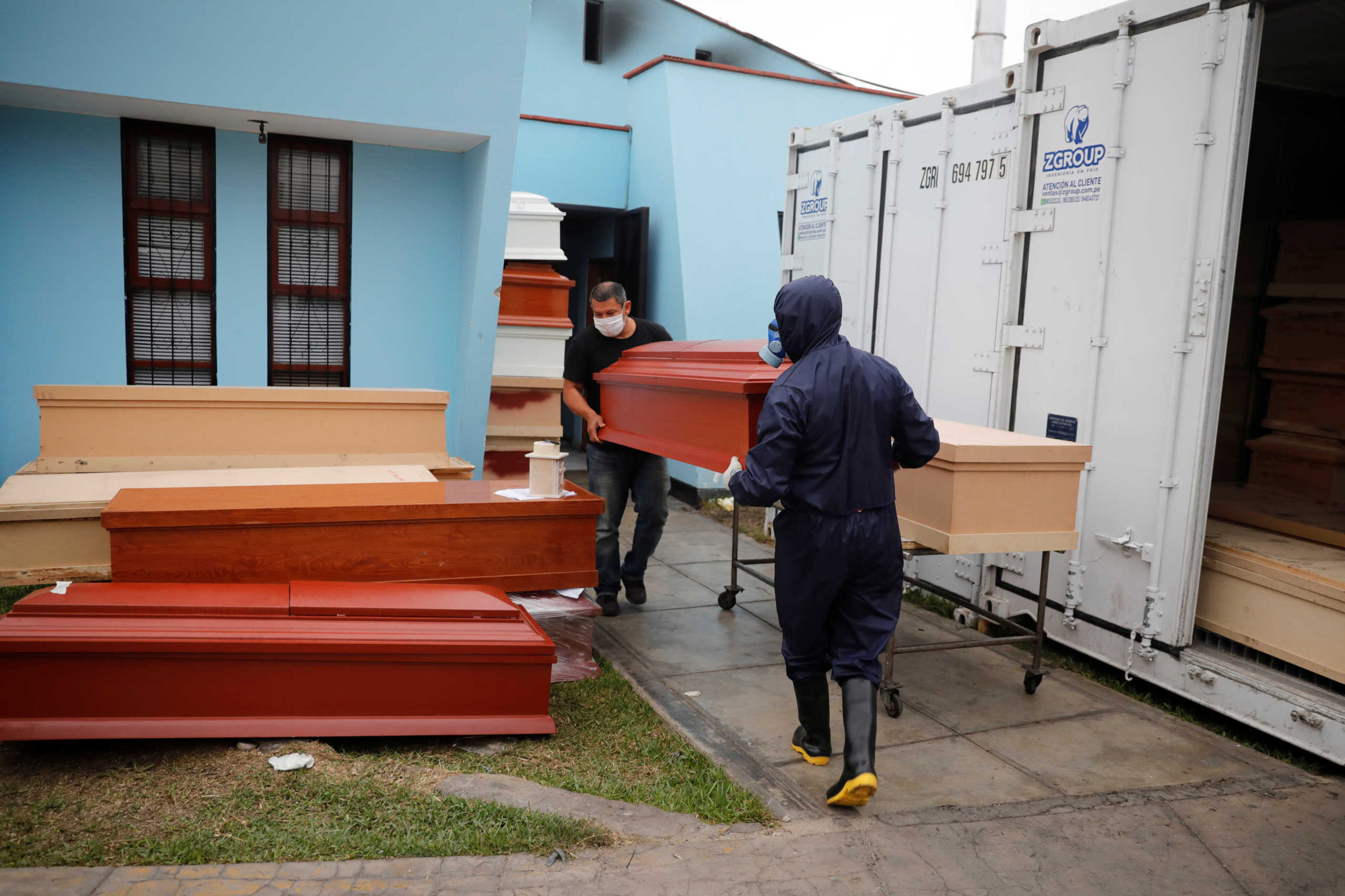Workers carry a coffin outside of the crematorium at Angel Cemetery, where victims of the coronavirus disease (COVID-19) are cremated in Lima, Peru May 25, 2020. REUTERS