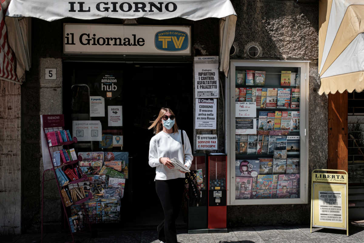 Life in Italy's original 'red zones': A woman leaves a newsagent with a newspaper in Codogno, the small northern town where Italy's first patient was diagnosed with the coronavirus disease (COVID-19) on February 21, as the country begins a staged end to a nationwide lockdown, in this picture taken by schoolteacher Marzio Toniolo, May 4, 2020. Codogno residents had been on lockdown for over 10 weeks, as they were part of a small cluster of northern towns where cases and deaths immediately surged after the first patient was diagnosed. Picture taken May 4, 2020. Marzio Toniolo via REUTERS THIS IMAGE HAS BEEN SUPPLIED BY A THIRD PARTY. MANDATORY CREDIT