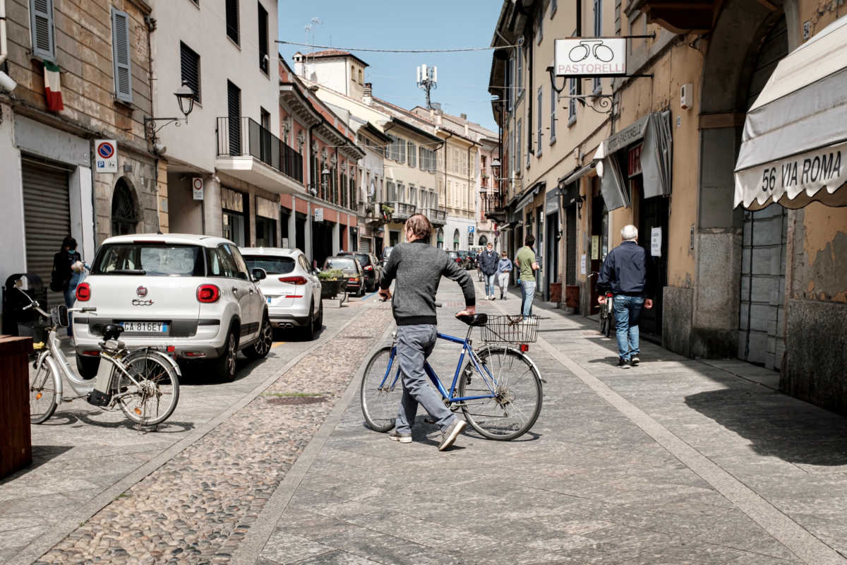 Life in Italy's original 'red zones': Residents wearing masks walk and cycle down a street in Codogno, the small northern town where Italy's first patient was diagnosed with the coronavirus disease (COVID-19) on February 21, as the country begins a staged end to a nationwide lockdown, in this picture taken by schoolteacher Marzio Toniolo, May 4, 2020. Codogno residents had been on lockdown for over 10 weeks, as they were part of a small cluster of northern towns where cases and deaths immediately surged after the first patient was diagnosed. Picture taken May 4, 2020. Marzio Toniolo via REUTERS THIS IMAGE HAS BEEN SUPPLIED BY A THIRD PARTY. MANDATORY CREDIT