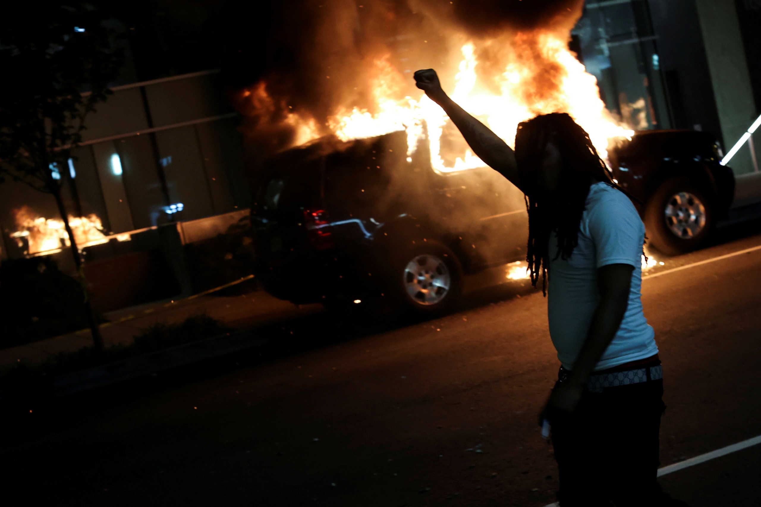 A man walks in front of a burning car as protesters continue to rally against the death in Minneapolis police custody of George Floyd, near the White House, in Washington, U.S., May 30, 2020.  REUTERS