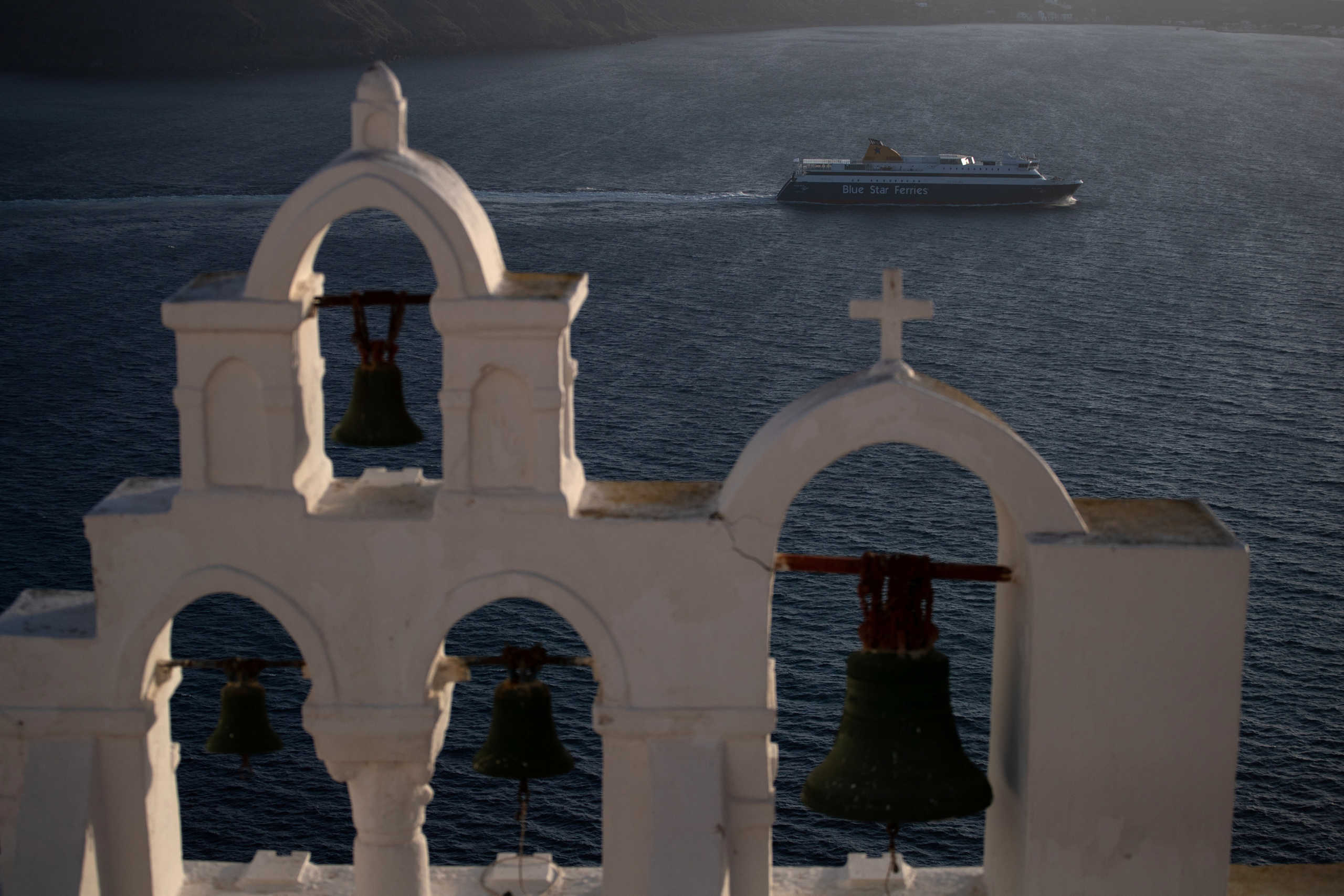 A ferry sails next to the caldera of Oia, following the coronavirus disease (COVID-19) outbreak, on the island of Santorini, Greece, May 6, 2020. Picture taken May 6, 2020. REUTERS