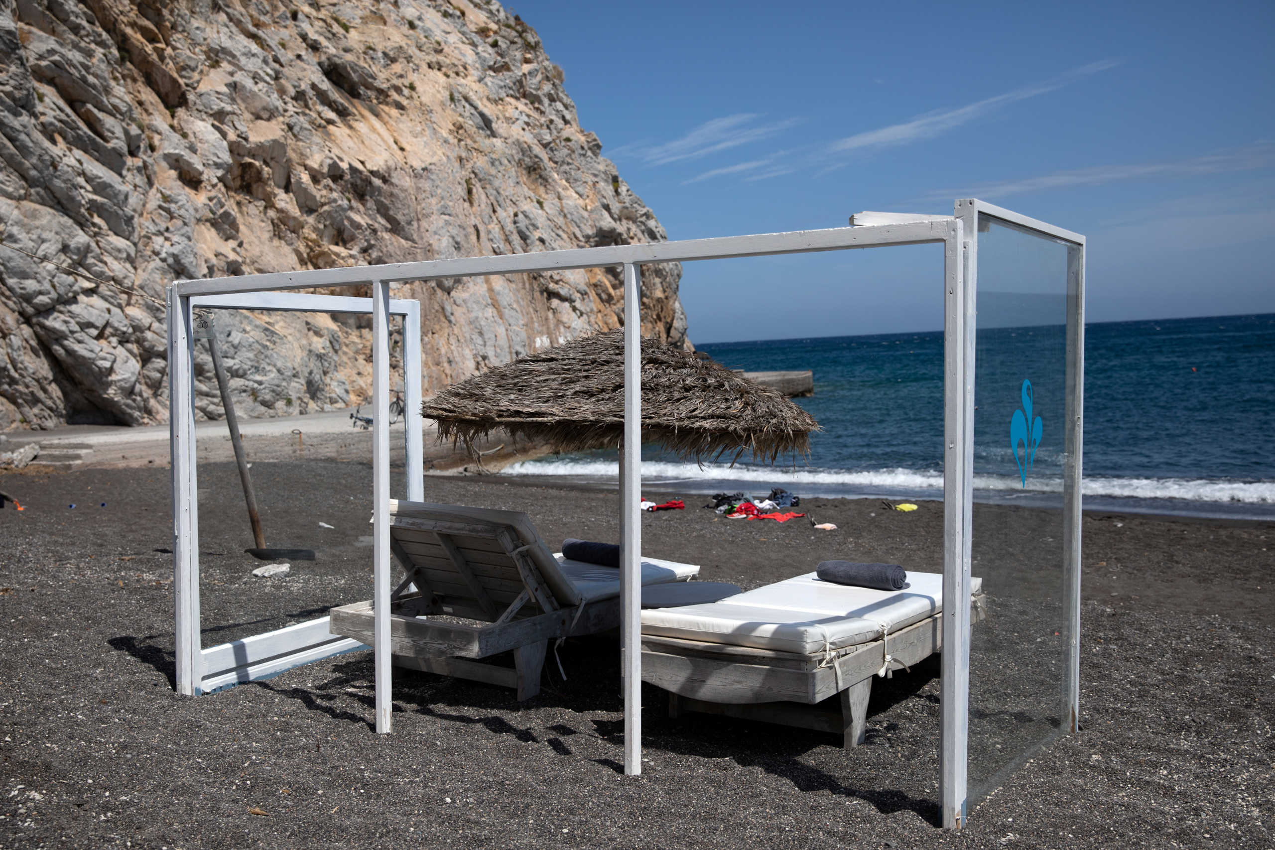 A plexiglas construction is set around an umbrella and sunbeds as a precaution against the coronavirus disease (COVID-19), on the beach of Perissa on the island of Santorini, Greece, May 7, 2020. REUTERS