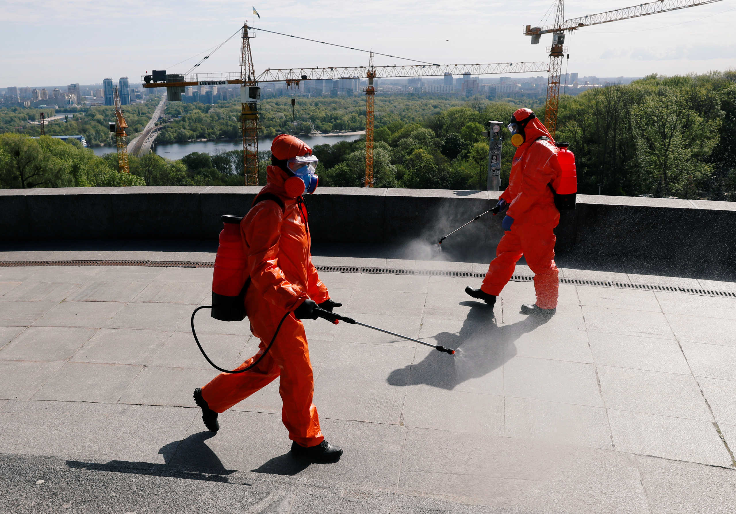 Members of Ukrainian State Emergency Service wearing protective gear spray disinfectant at the Tomb of the Unknown Soldier to prevent the spread of coronavirus disease (COVID-19) as Ukrainians mark the Victory Day, the 75th anniversary of the victory over Nazi Germany in World War Two in Kiev, Ukraine May 9, 2020.  REUTERS