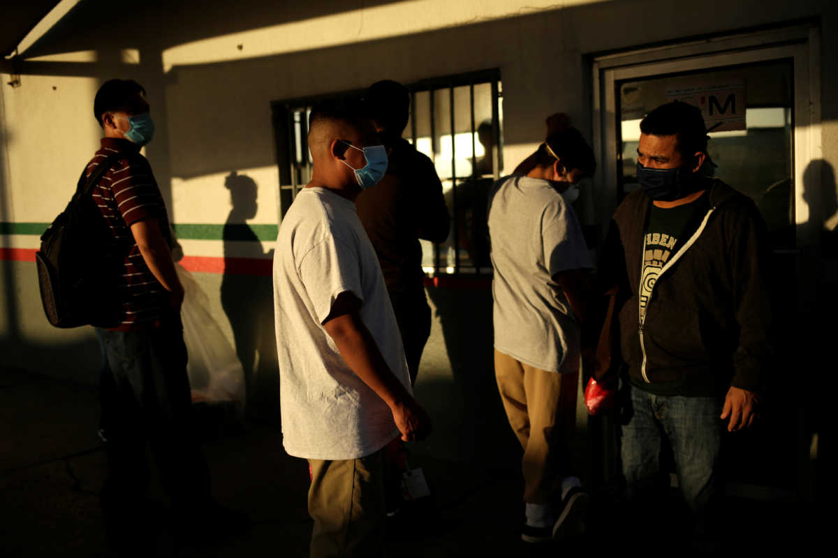 Mexican immigrants wait outside of the National Institute of Migration (INM) building after being deported from the United States at the Paso del Norte border bridge amid the spread of the coronavirus disease (COVID-19), in Ciudad Juarez, Mexico April 29, 2020. REUTERS