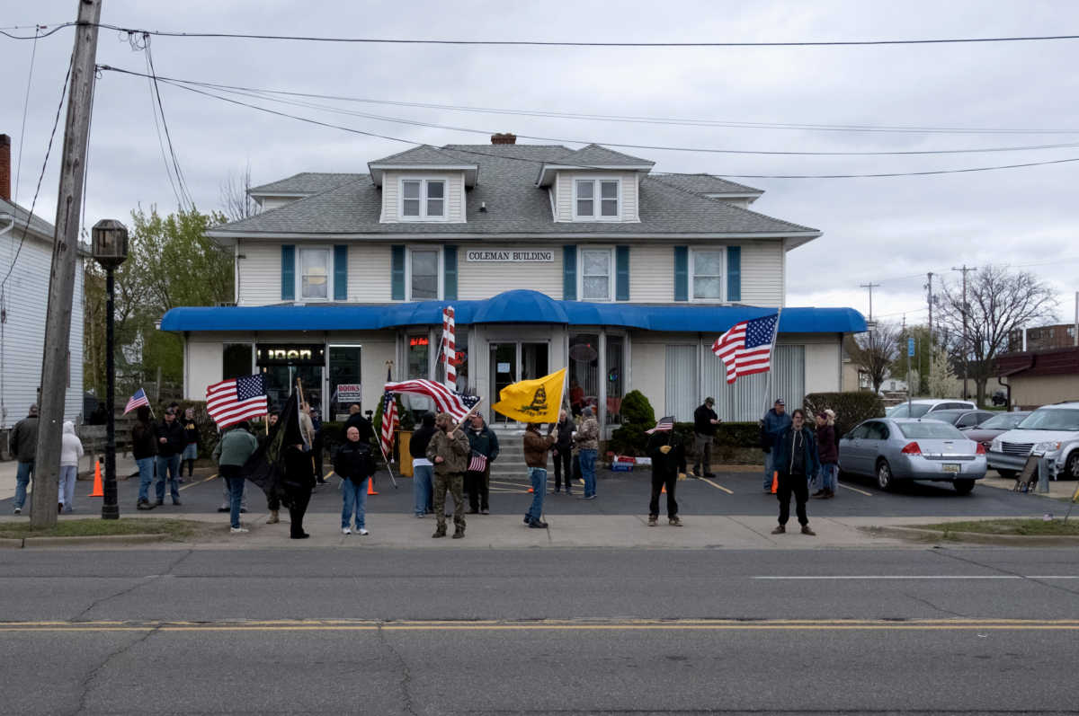A small group of protesters protest outside the barbershop of Karle Manke, 77, who has been defying the coronavirus disease (COVID-19) executive order of Governor Gretchen Whitmer in Owosso, Michigan, U.S. May 11, 2020. REUTERS