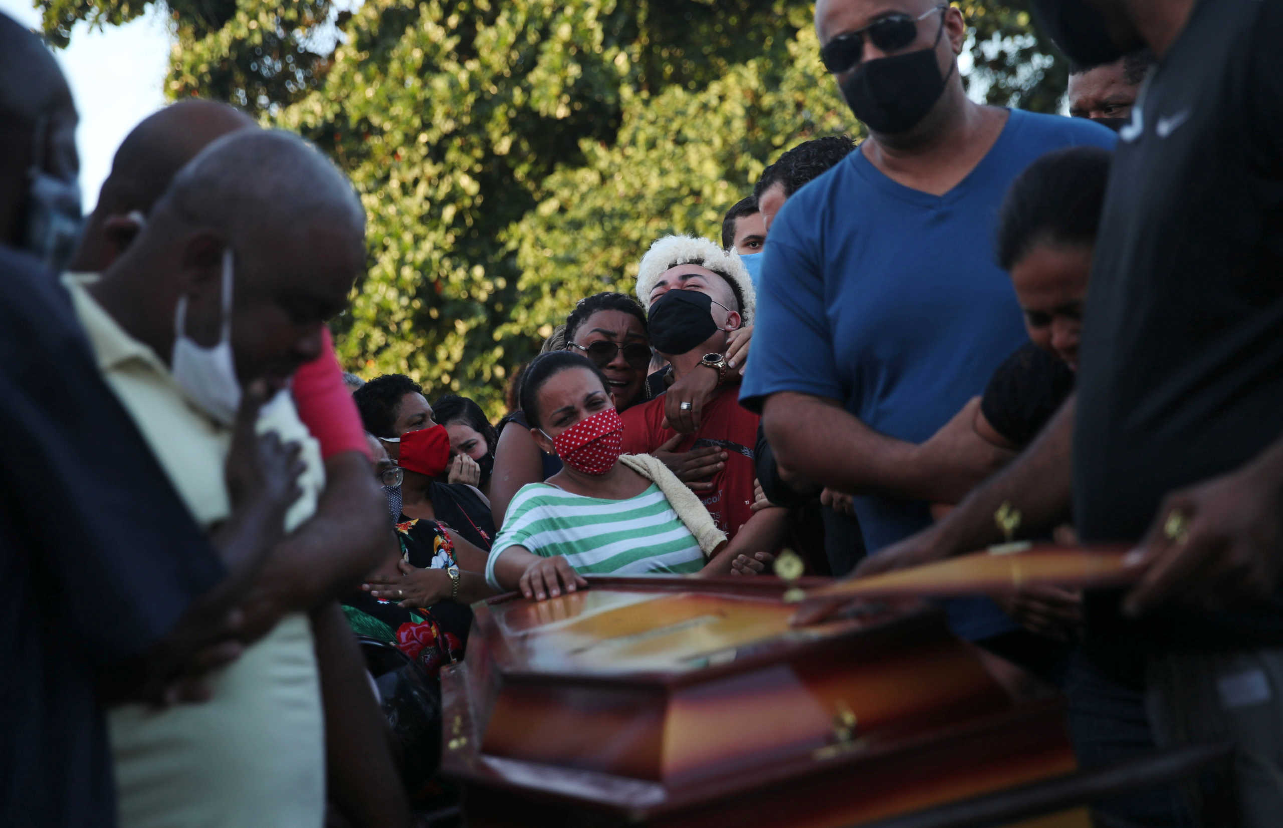 Relatives and friends, some wearing face masks due to the global outbreak of the coronavirus disease (COVID-19), mourn during the funeral of teenager Joao Pedro Pinto, 14, who according to residents was shot dead during a police operation against drug dealers, in Salgueiro slum in Sao Goncalo near Rio de Janeiro, Brazil, May 19, 2020. REUTERS