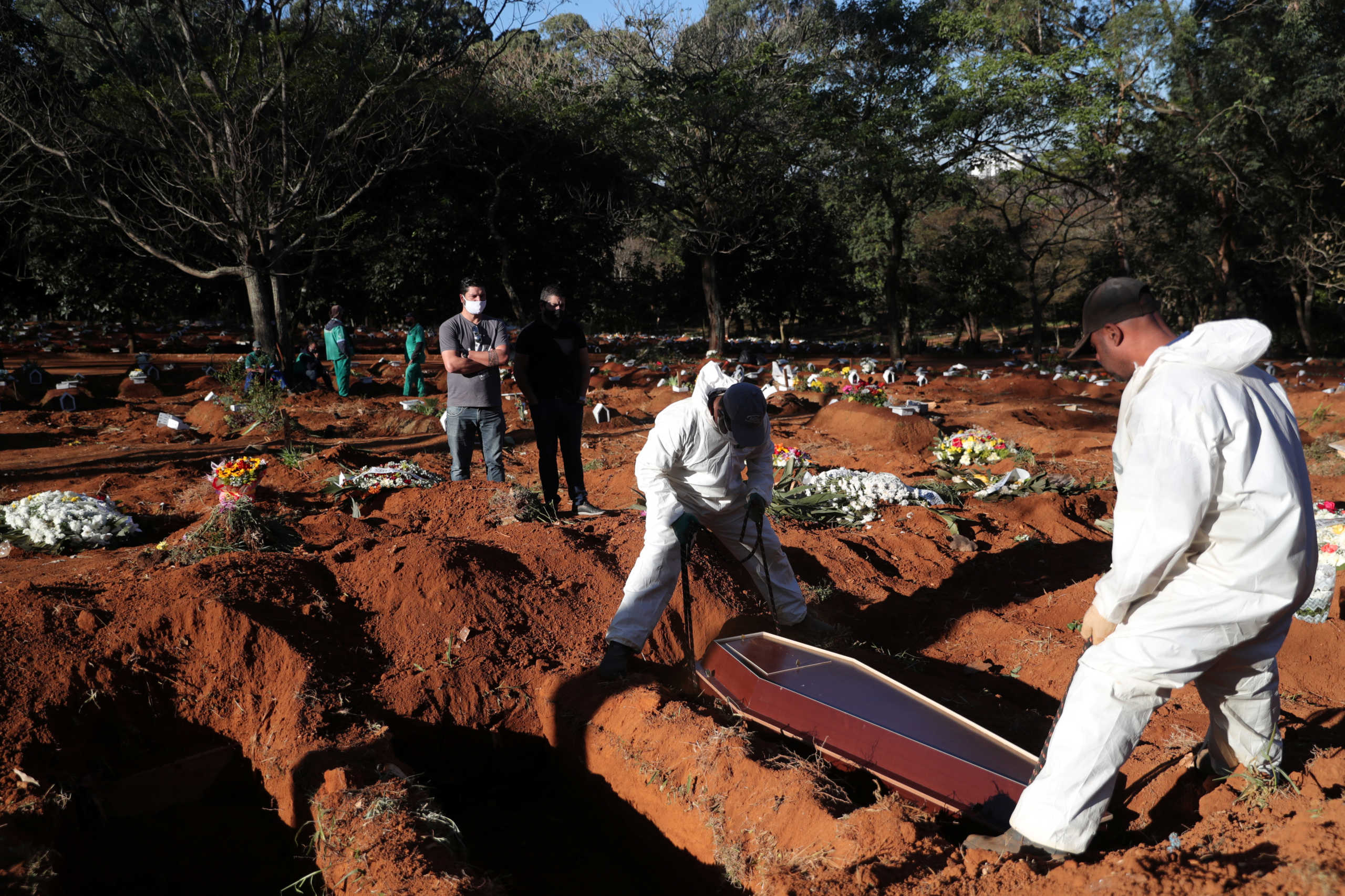 Gravediggers wearing protective suits bury the coffin of Izolina de Sousa, 85, who died from the coronavirus disease (COVID-19), at Vila Formosa cemetery, Brazil's biggest cemetery, in Sao Paulo, Brazil, May 26, 2020. REUTERS