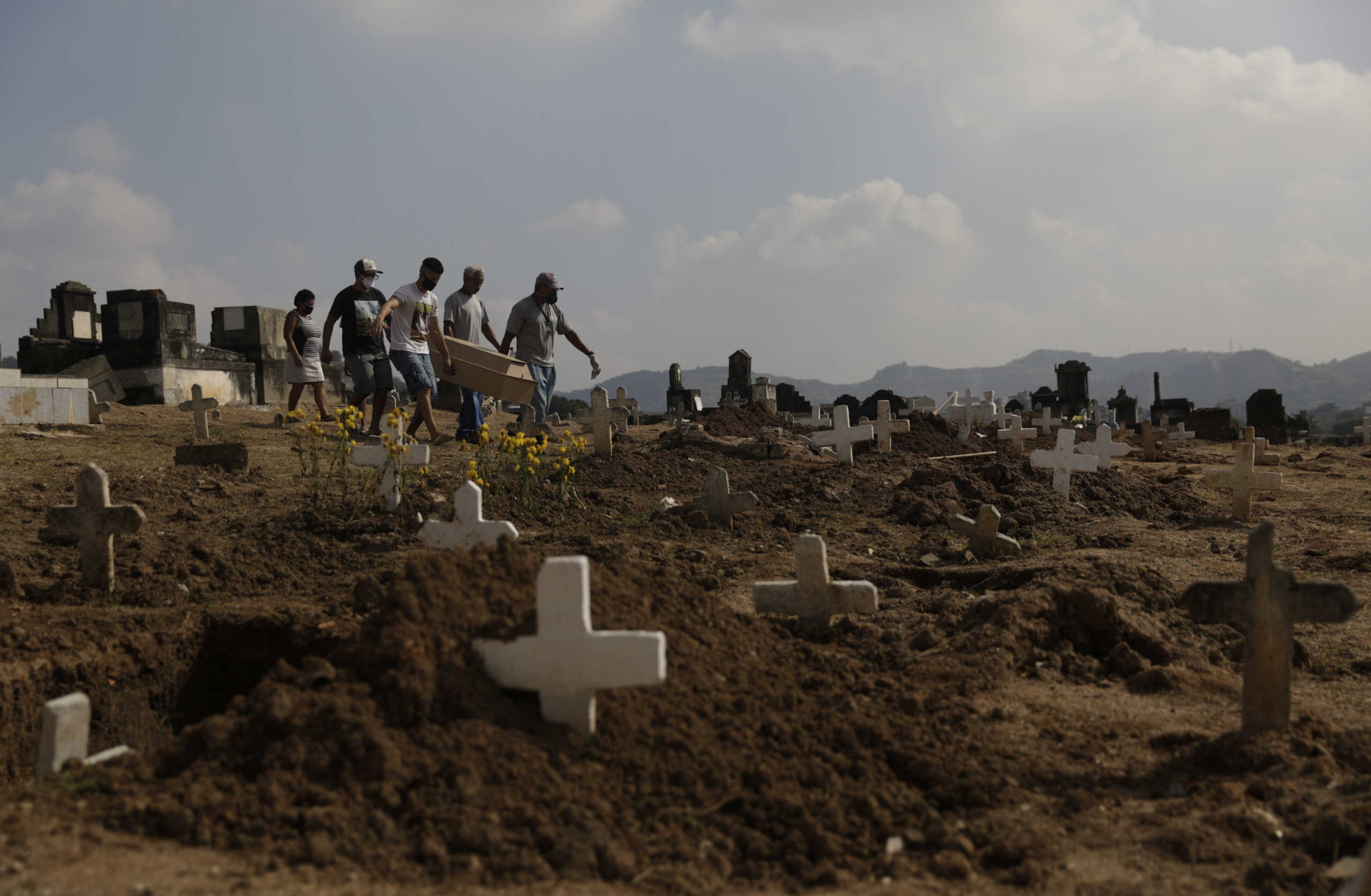 Marcos Vinicius Andrade da Silva, 26, helps to carry the coffin of Valnir Mendes da Silva, 62, who died on a sidewalk in the Arara slum after experiencing difficulty breathing, at his funeral at Cemiterio de Inhauma, during the coronavirus disease (COVID-19) outbreak, in Inhauma, Rio de Janeiro, Brazil, May 18, 2020. Valnir da Silva died on the streets of a poor Rio de Janeiro neighborhood. His body lay on the sidewalk for 30 hours, according to relatives and neighbors. REUTERS