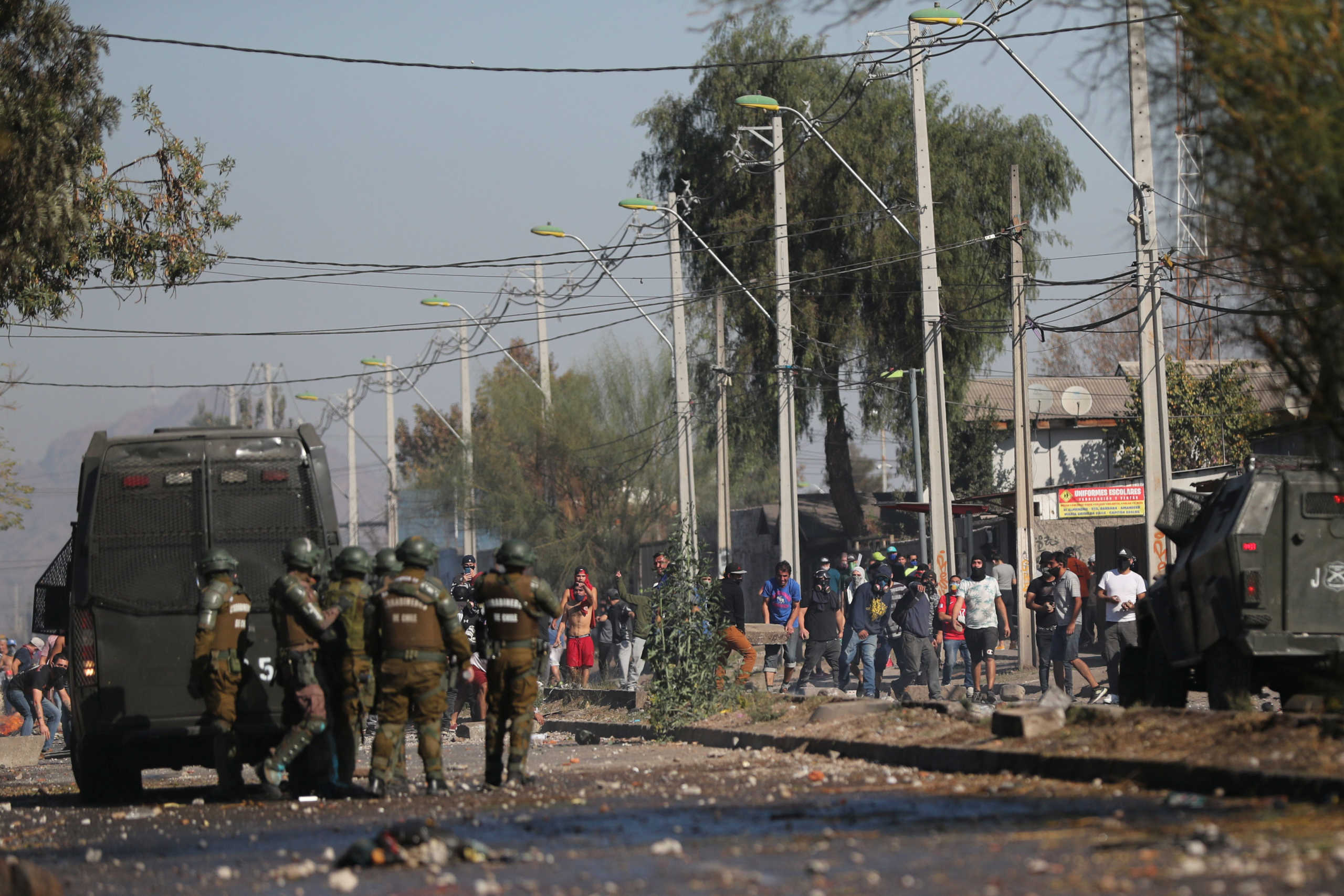 People from a poor neighborhood clash with riot police while protesting against the lack of help from the government during a general quarantine imposed due to a surge of fresh coronavirus disease (COVID-19) cases, at 'El Bosque' area in Santiago, Chile May 18, 2020. REUTERS