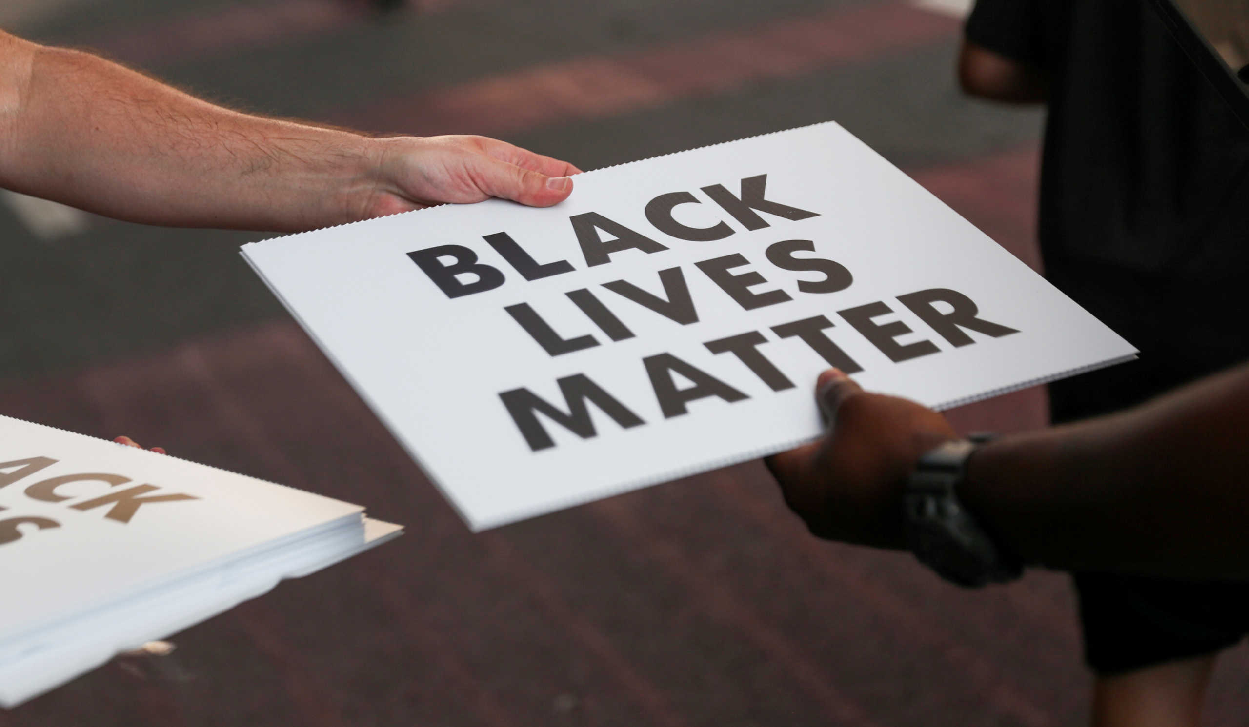 Protesters hand out Black Lives Matter placards during racial inequality protests in Washington, U.S., June 23, 2020. REUTERS
