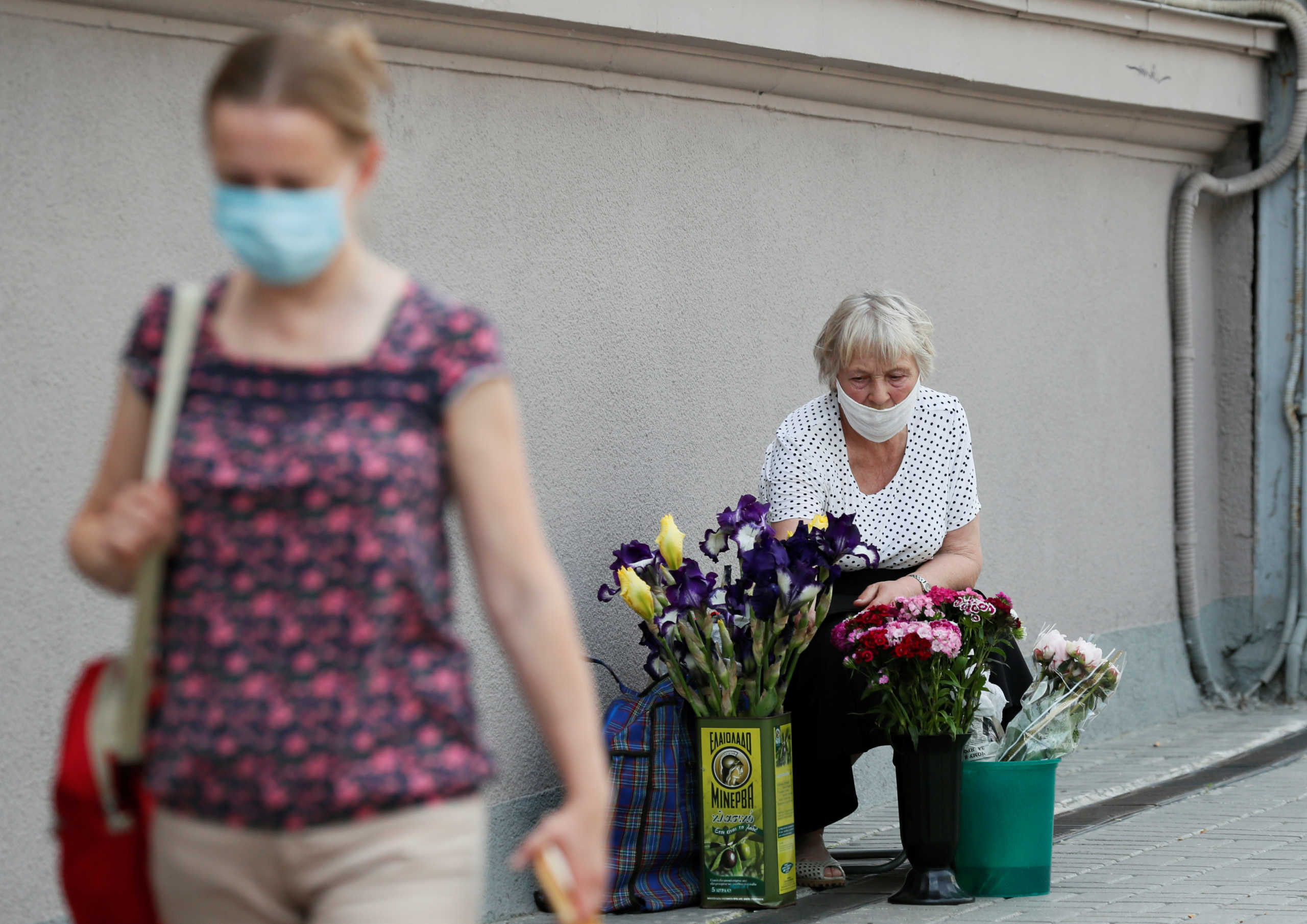 An elderly woman wearing a protective face mask sells flowers amid the outbreak of the coronavirus disease (COVID-19) in central Kiev, Ukraine June 9, 2020. REUTERS