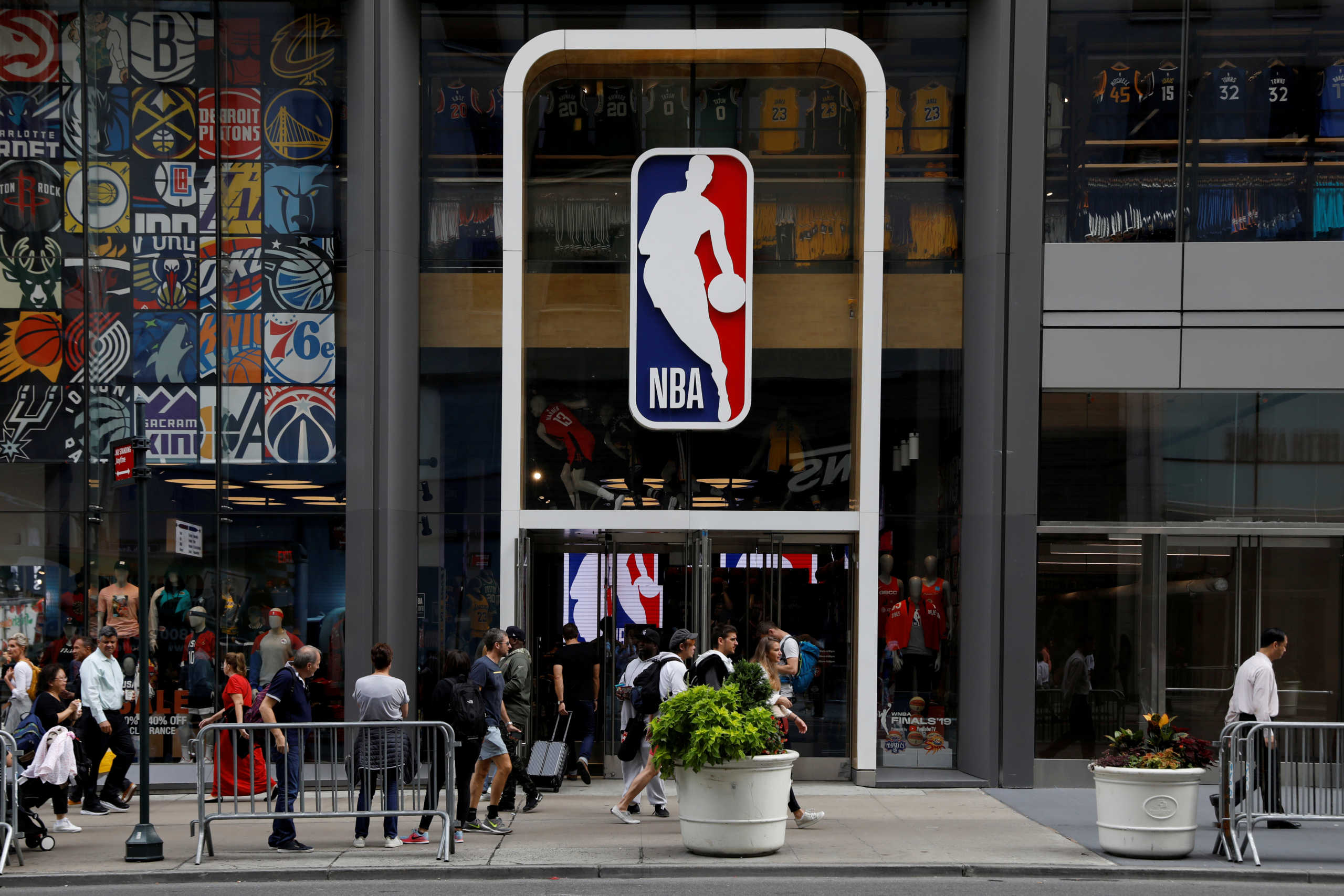 FILE PHOTO: The NBA logo is displayed as people pass by the NBA Store in New York City, U.S., October 7, 2019. REUTERS