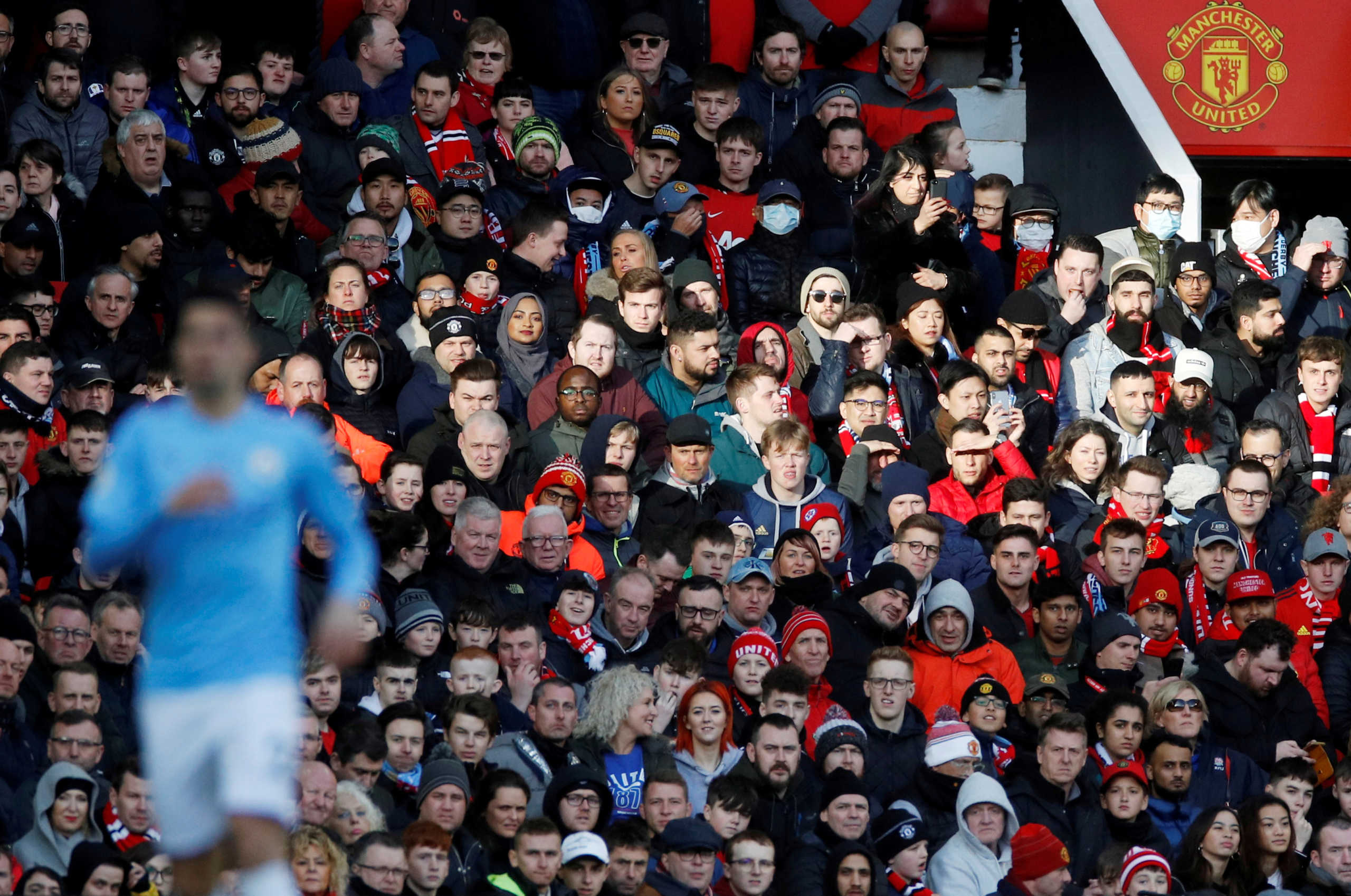 FILE PHOTO: Soccer Football - Premier League - Manchester United v Manchester City - Old Trafford, Manchester, Britain - March 8, 2020  General view as some fans wear masks for protection against the novel coronavirus. REUTERS