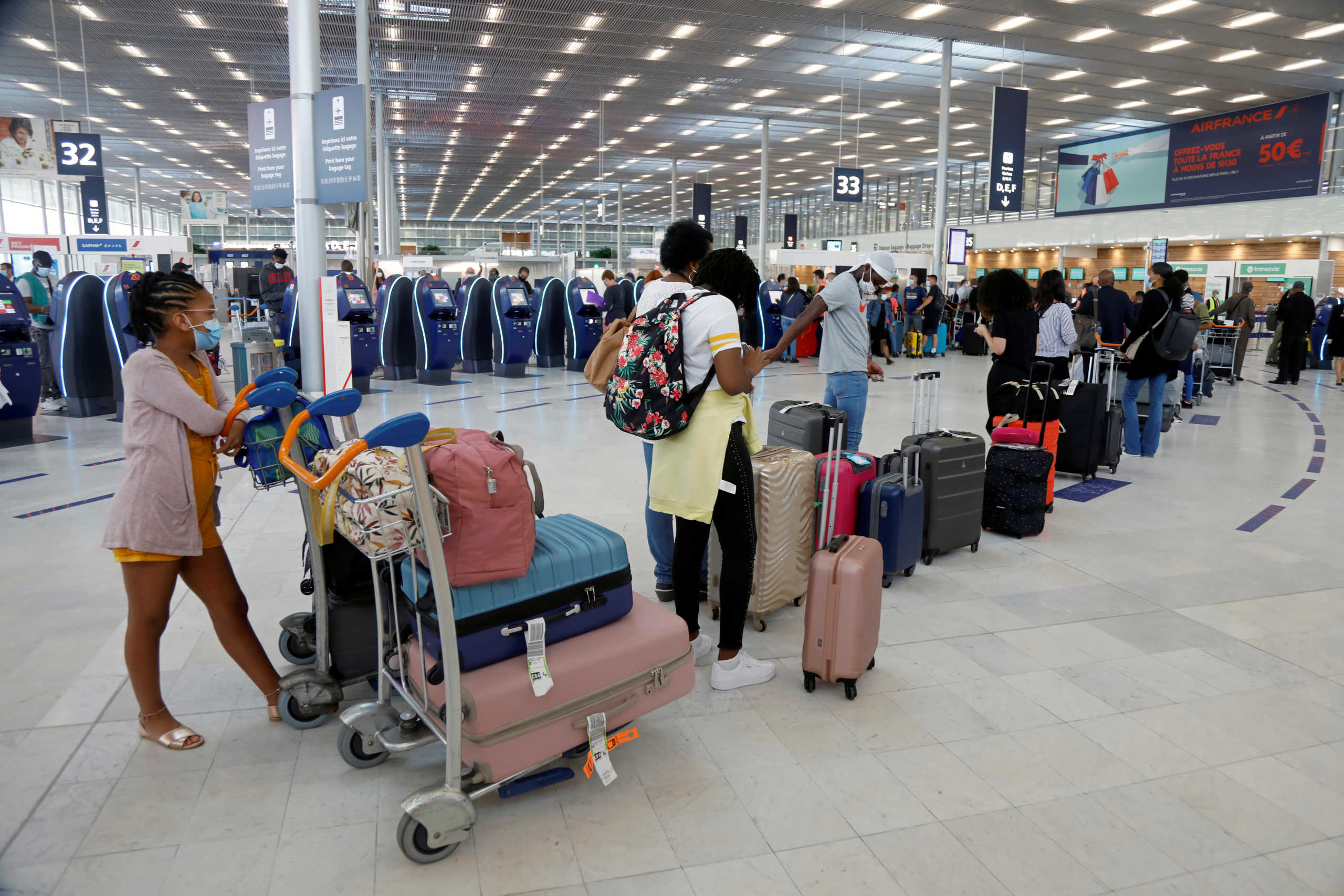 Passengers queue at the baggage drop-off as the Paris' Orly Airport reopens following the coronavirus disease (COVID-19) outbreak in France, June 26, 2020. REUTERS