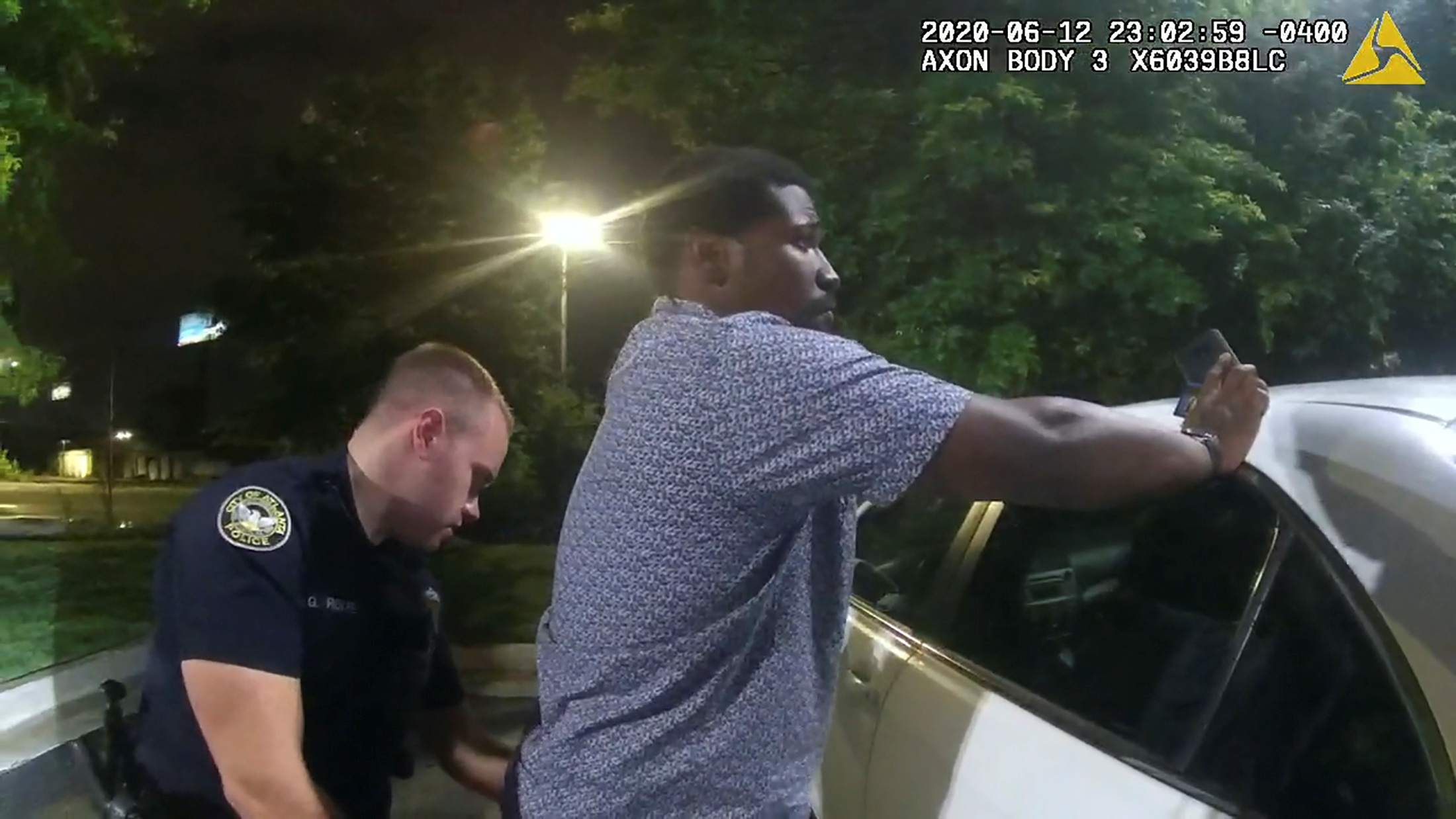 Former Atlanta Police Department officer Garrett Rolfe searches 27-year-old Rayshard Brooks in a Wendy's restaurant parking lot in a still image from the video body camera of officer Devin Bronsan in Atlanta, Georgia, U.S. June 12, 2020. Video taken June 12, 2020. Atlanta Police Department