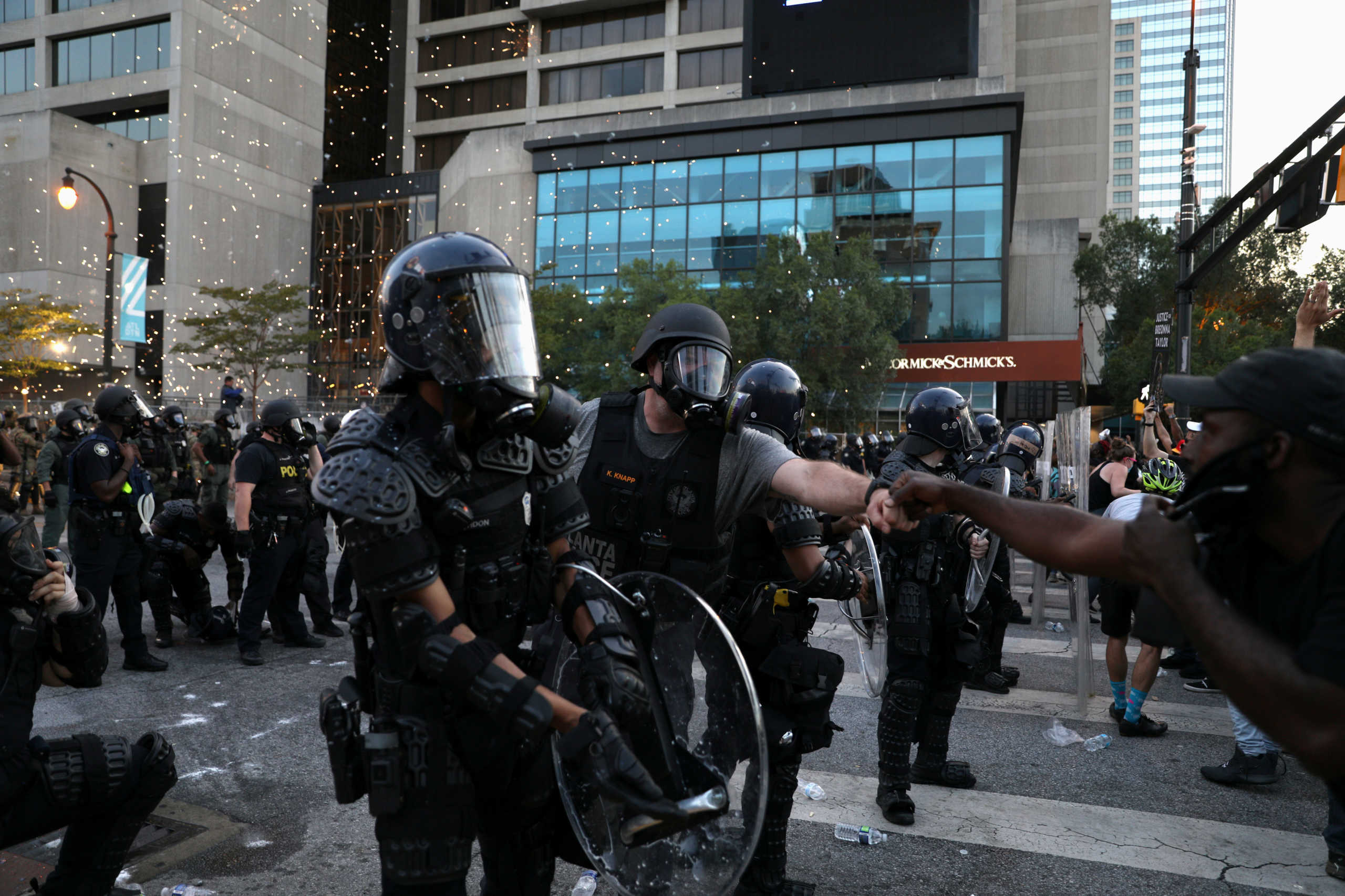 Police and protester fist-bump as a firework goes off during a police standoff at a protest against the death in Minneapolis in police custody of African-American man George Floyd, in Atlanta, Georgia, U.S. June 1, 2020. REUTERS