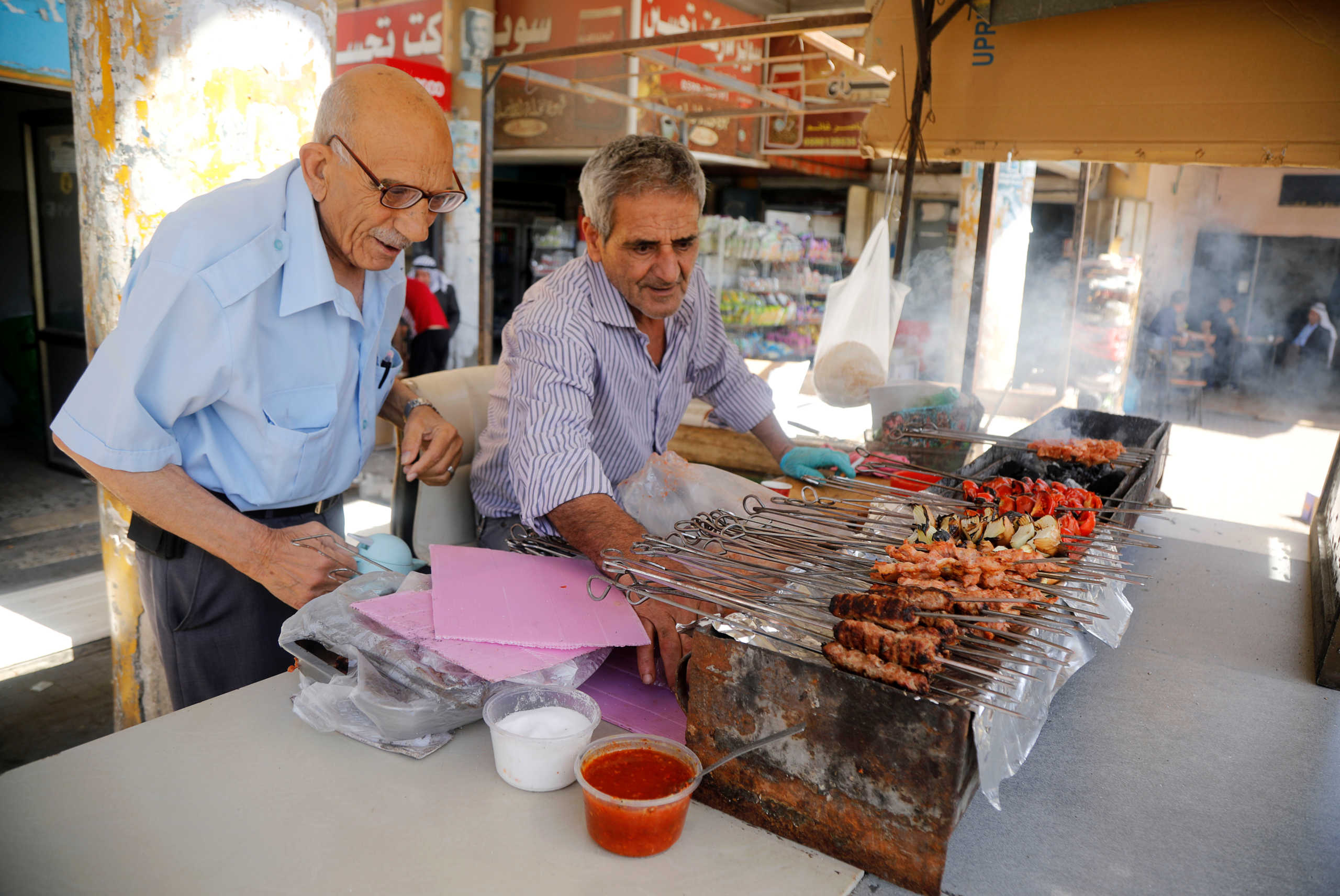 A worker prepares grilled shish kebabs for a customer at a restaurant as Palestinians ease the coronavirus disease (COVID-19) restrictions, in Jenin in the Israeli-occupied West Bank May 31, 2020. REUTERS