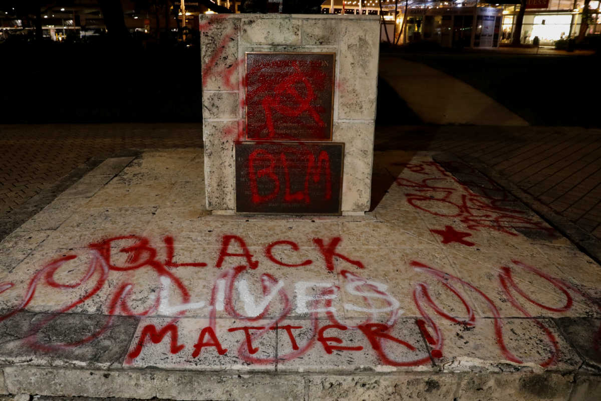 Graffiti is seen on a vandalized statue of Christopher Columbus at the Bayside Marketplace, after a protest against racial inequality in the aftermath of the death in Minneapolis police custody of George Floyd, in Downtown Miami, Florida, U.S., June 10, 2020. REUTERS