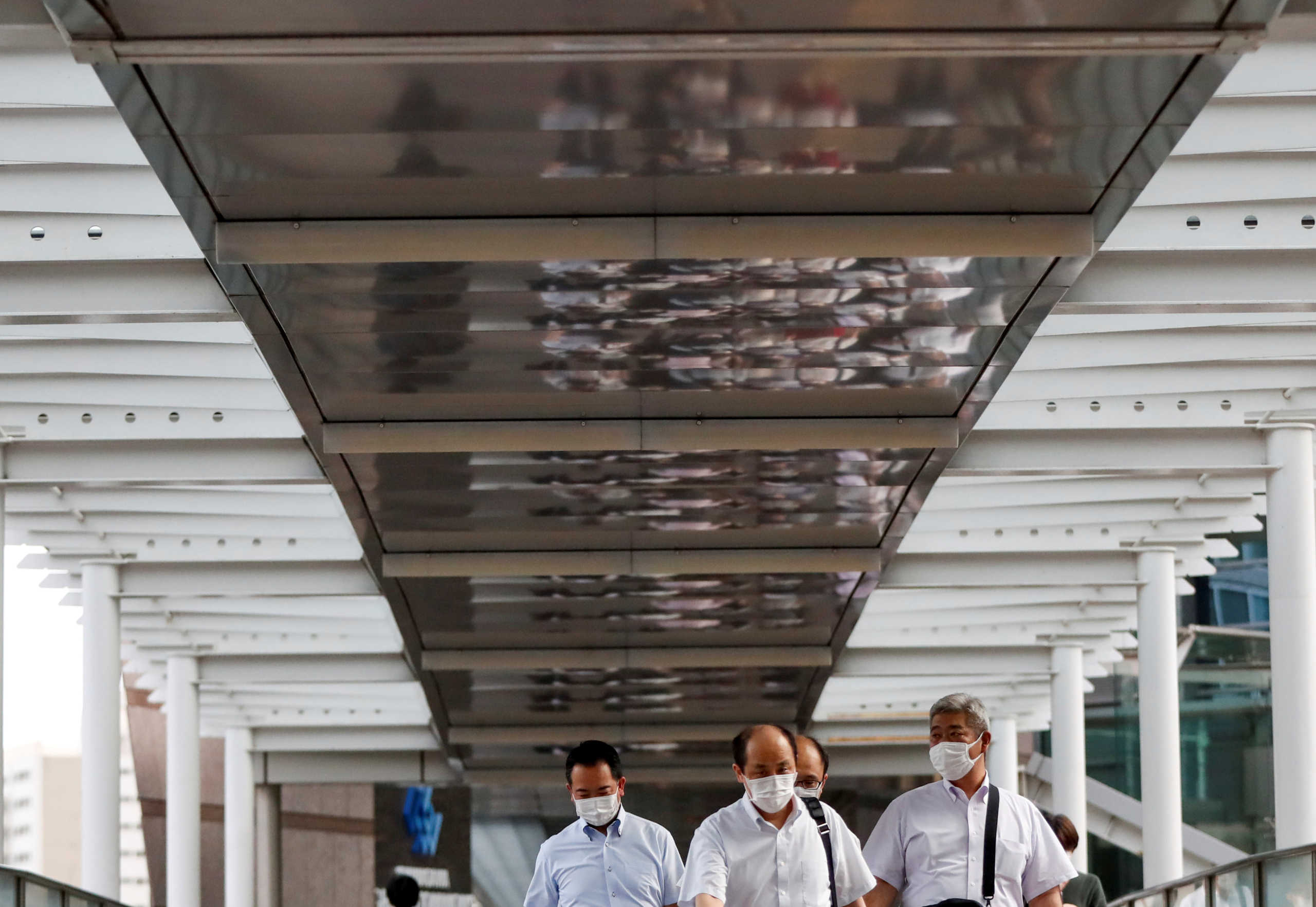 Passersby wearing protective face masks head home as the spread of the coronavirus disease (COVID-19) continues, at a station in Tokyo, Japan June 24, 2020.  REUTERS
