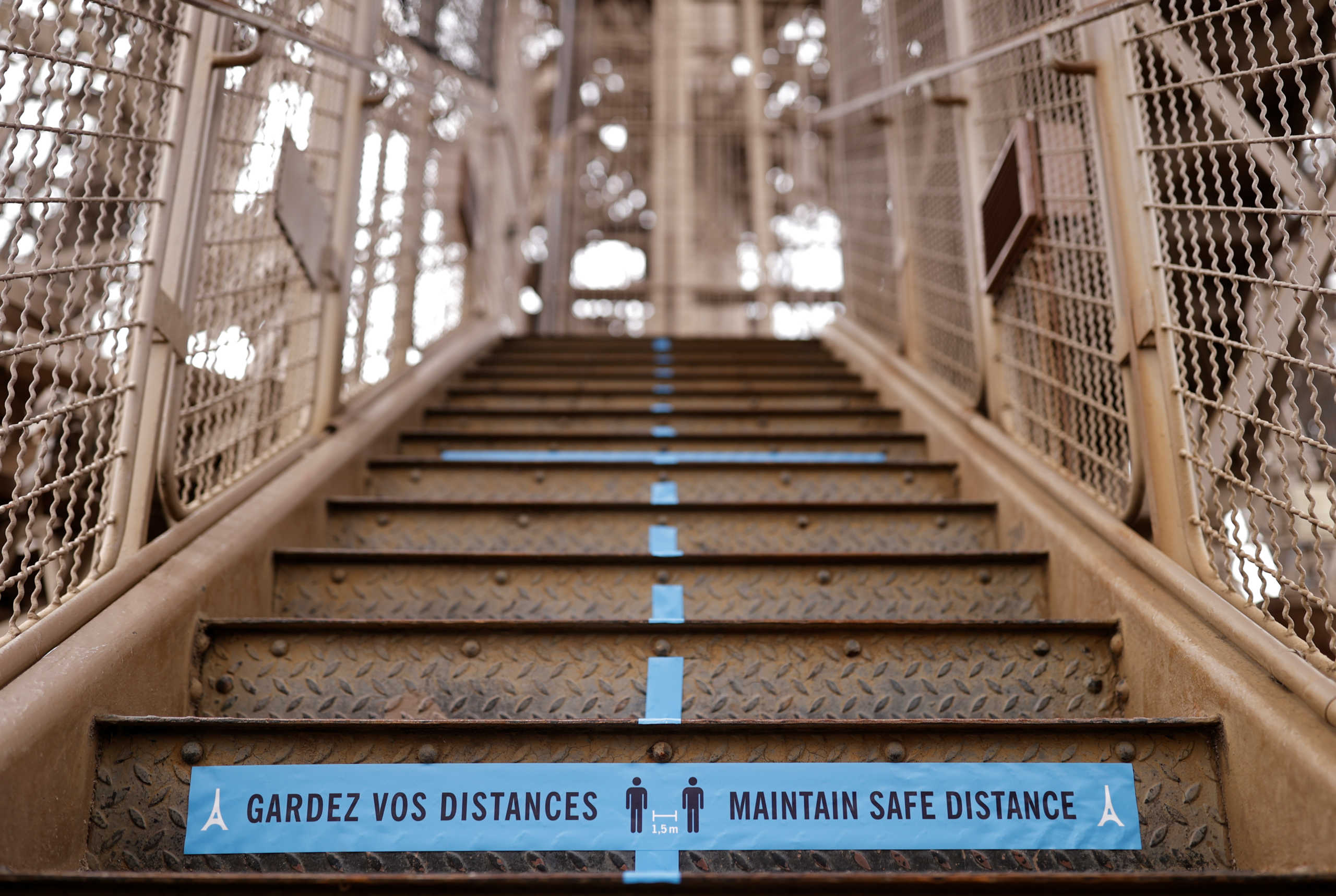 A sign reminding about social distancing is seen at the Eiffel Tower as she gets ready to re-open to the public following the coronavirus outbreak, in Paris, France, June 17, 2020.  REUTERS