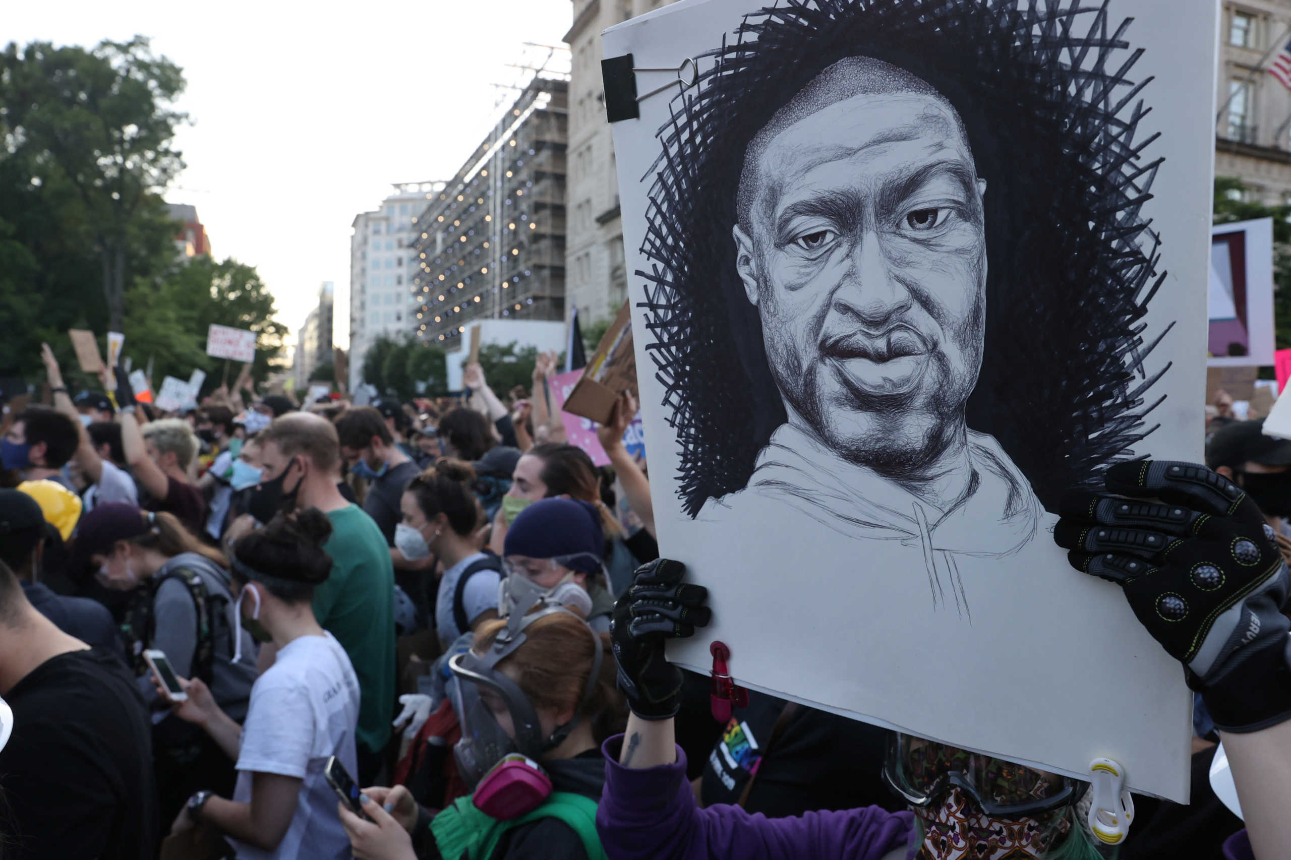 A demonstrator holds a placard depicting George Floyd as protests continue over his death in police custody, in Washington, U.S., June 2, 2020. REUTERS