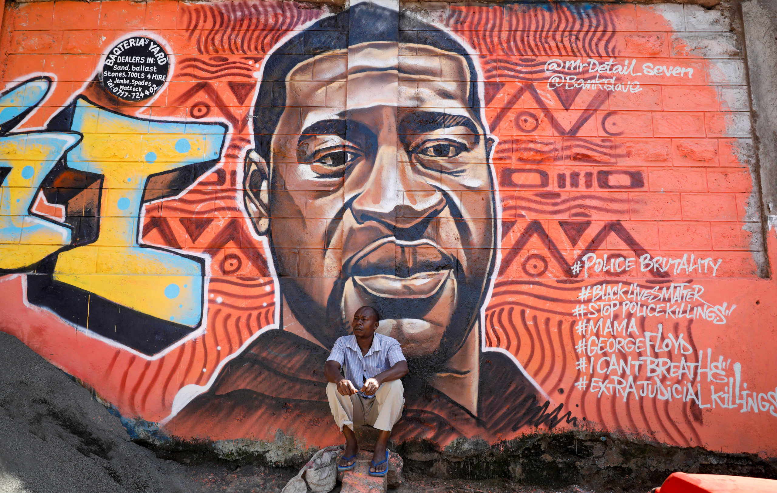 A man sits under a graffiti depicting African-American man George Floyd, who died in Minneapolis police custody, at the Kibera slum of Nairobi, Kenya, June 4,2020.REUTERS