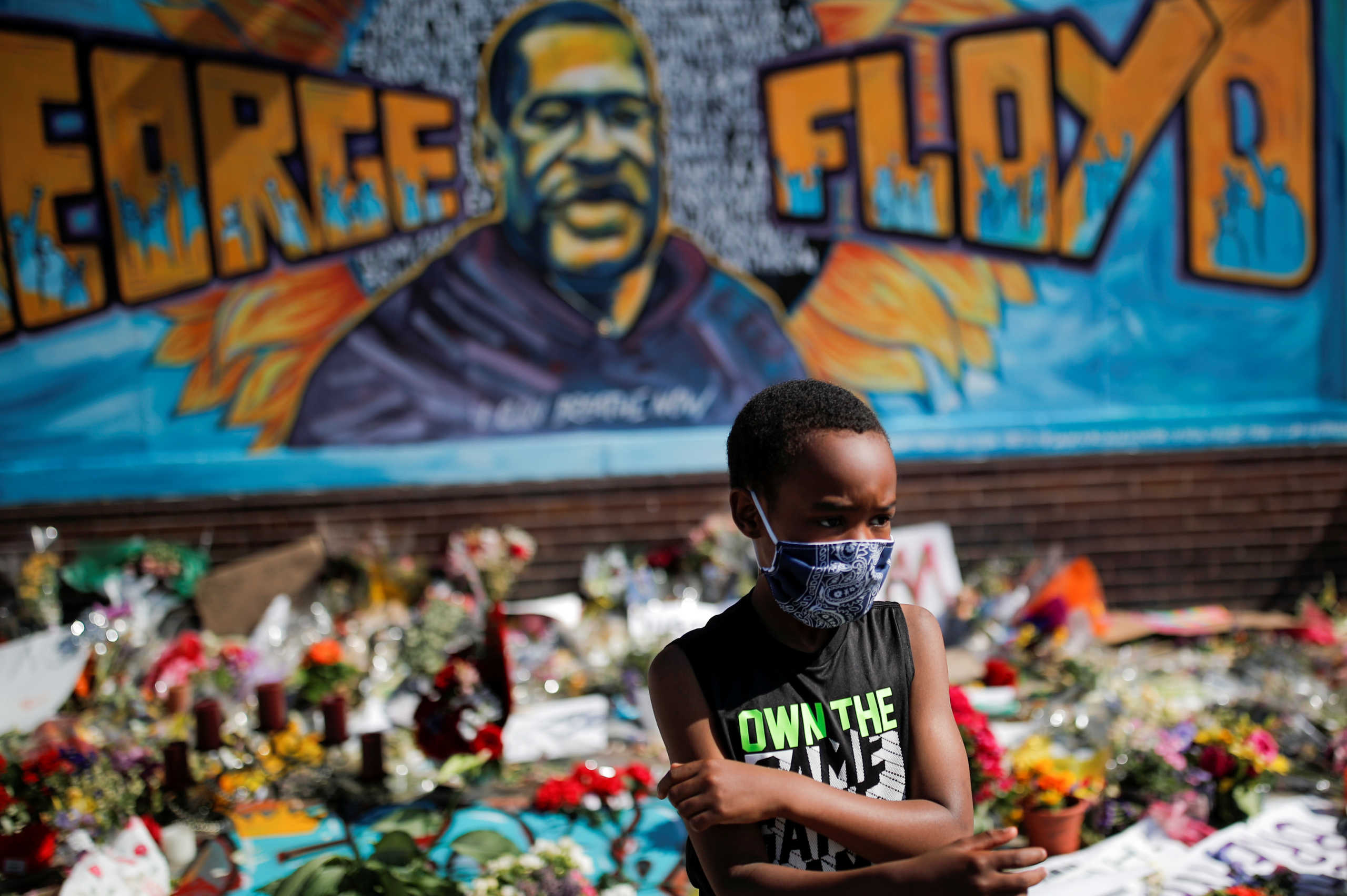 A child wears a protective mask at a makeshift memorial honoring George Floyd, at the spot where he was taken into custody, in Minneapolis, Minnesota, U.S., June 1, 2020.  REUTERS