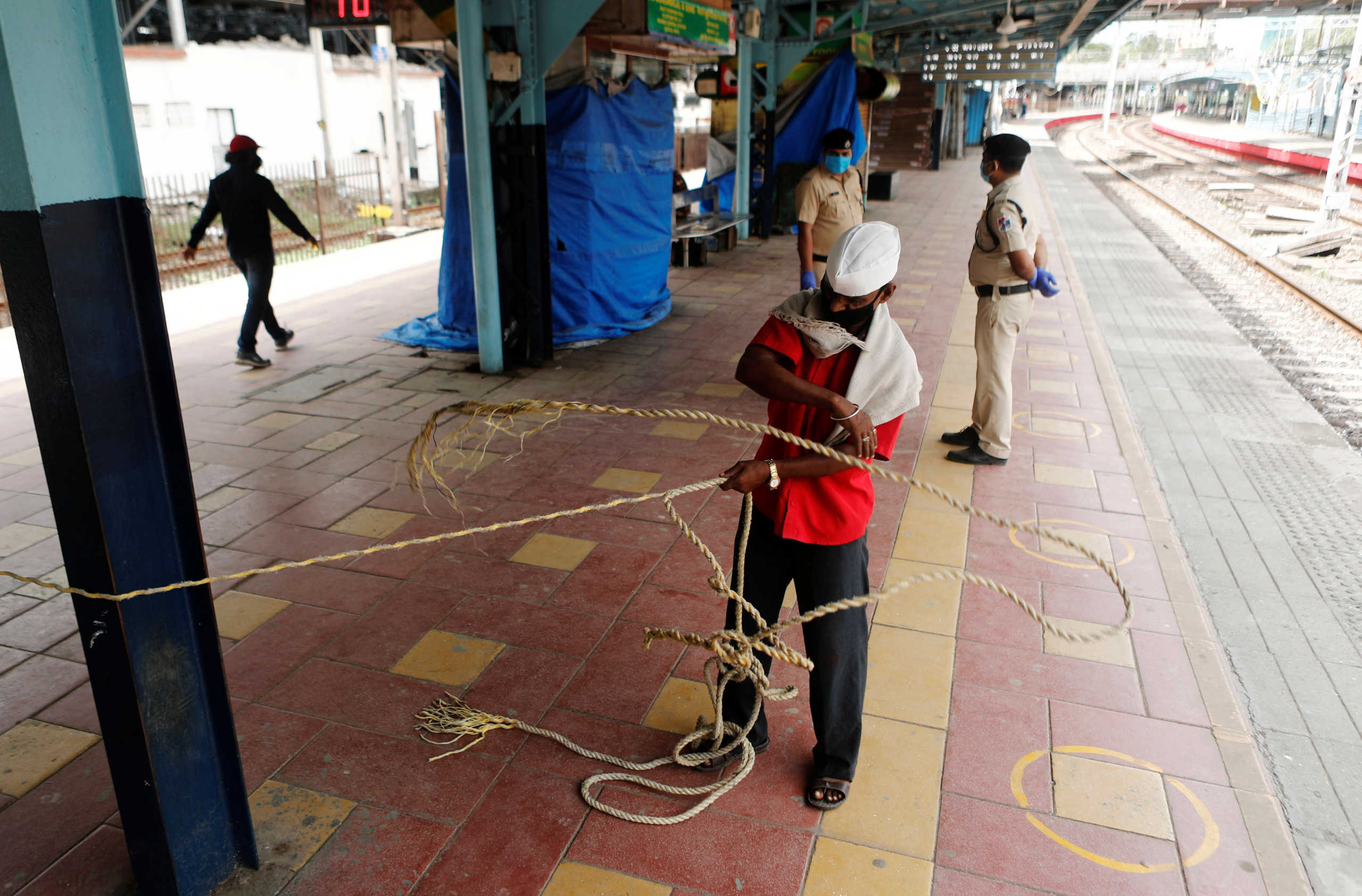 A man ties a rope to a pillar on a platform after some restrictions were lifted during a nationwide lockdown to slow the spread of the coronavirus disease (COVID-19), in Mumbai, India, June 15, 2020. REUTERS