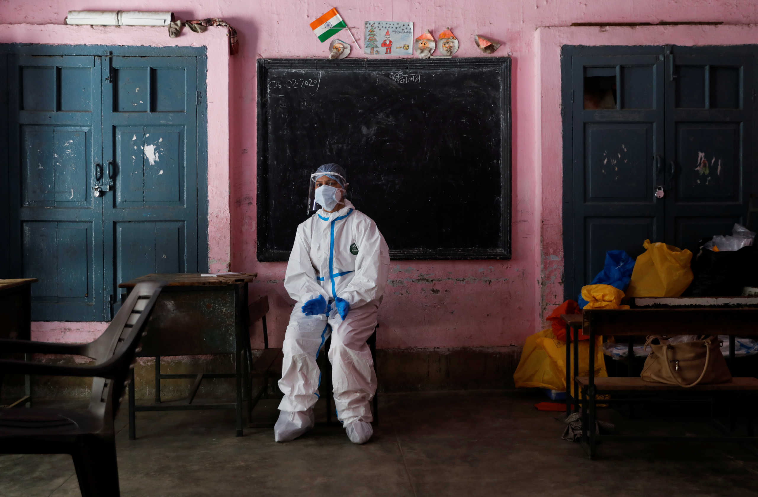 A medical worker sits inside a classroom as she takes a break at a school, which was turned into a centre to conduct tests for the coronavirus disease (COVID-19), amidst its spread in New Delhi, India June 22, 2020. REUTERS