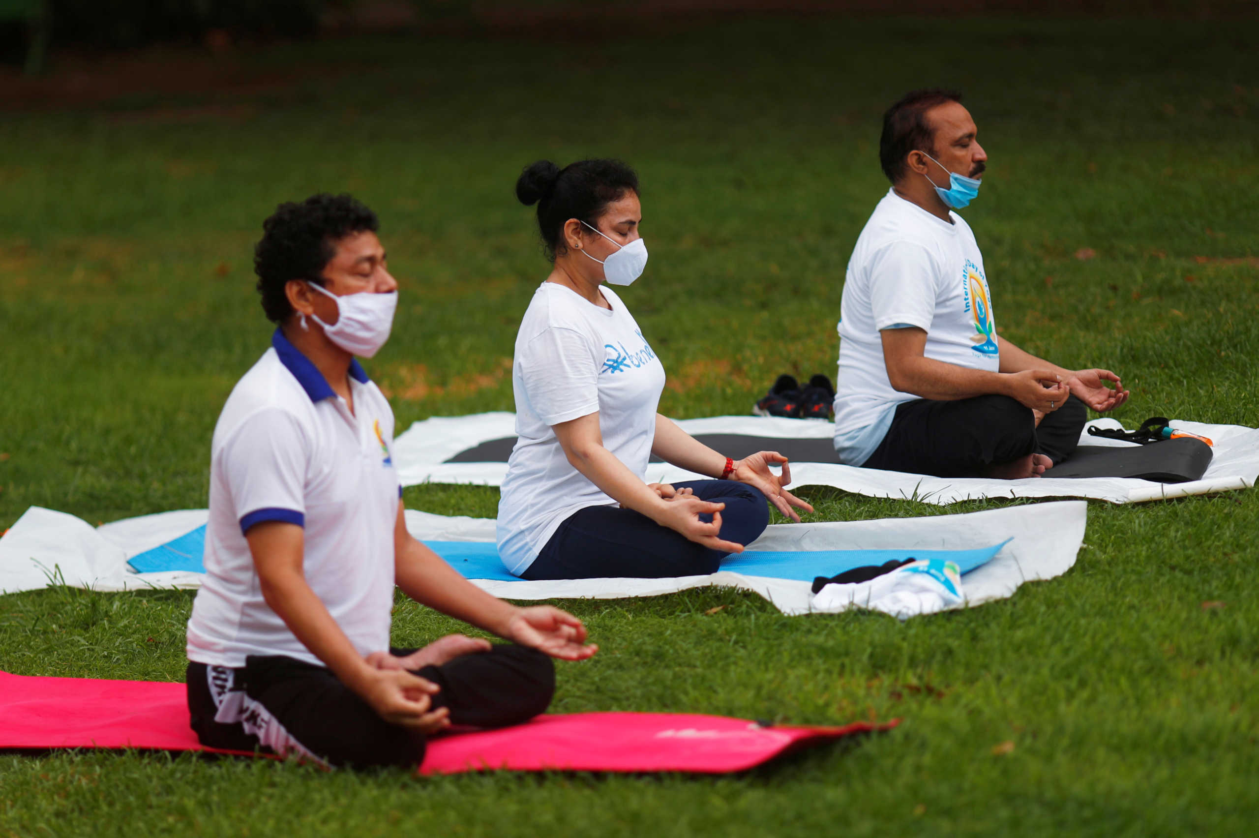 Participants wearing protective face masks against the coronavirus disease (COVID-19) outbreak, perform yoga during World Yoga Day in New Delhi, India, June 21, 2020. REUTERS