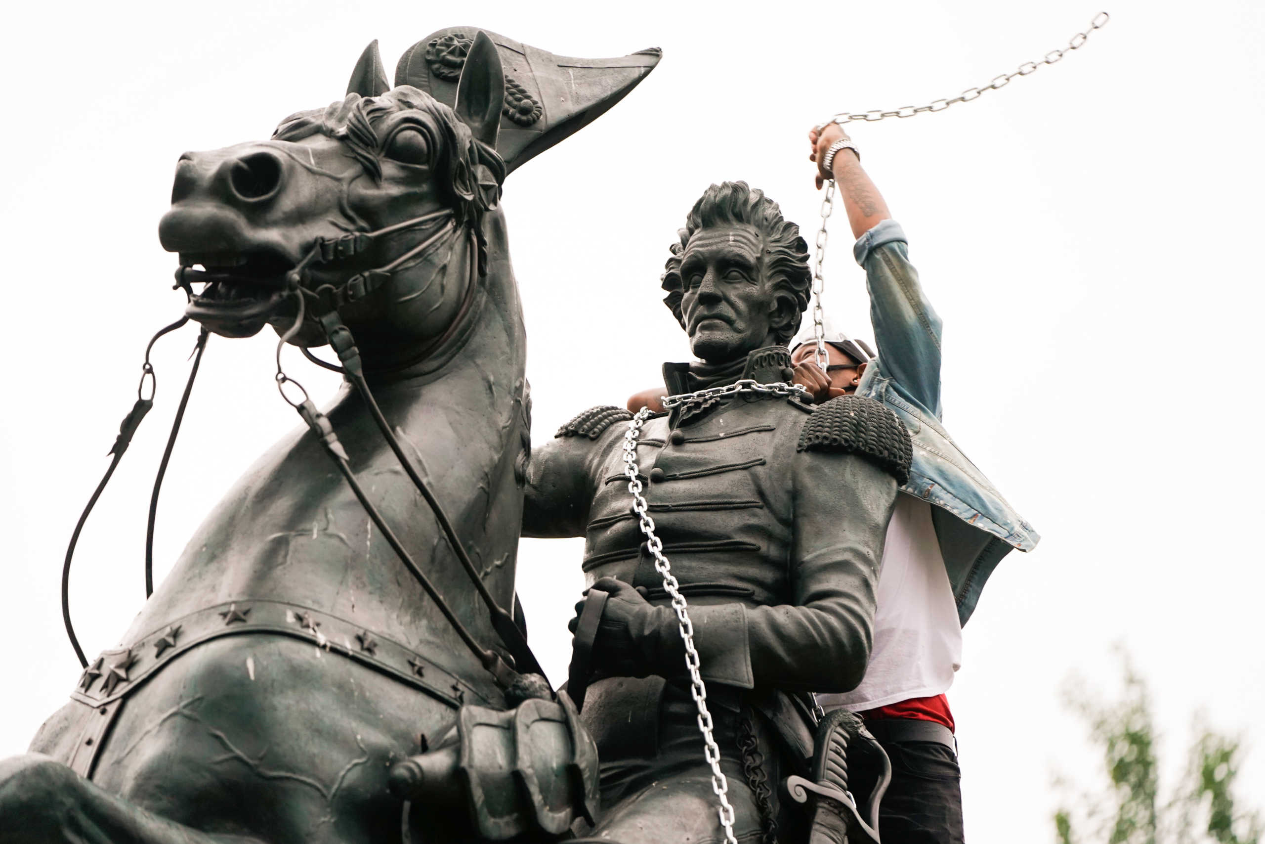 A protestor wraps chains around the neck of the statue of U.S. President Andrew Jackson during an attempt by protestors to pull the statue down in the middle of Lafayette Park in front of the White House during racial inequality protests in Washington, D.C., U.S., June 22, 2020. REUTERS