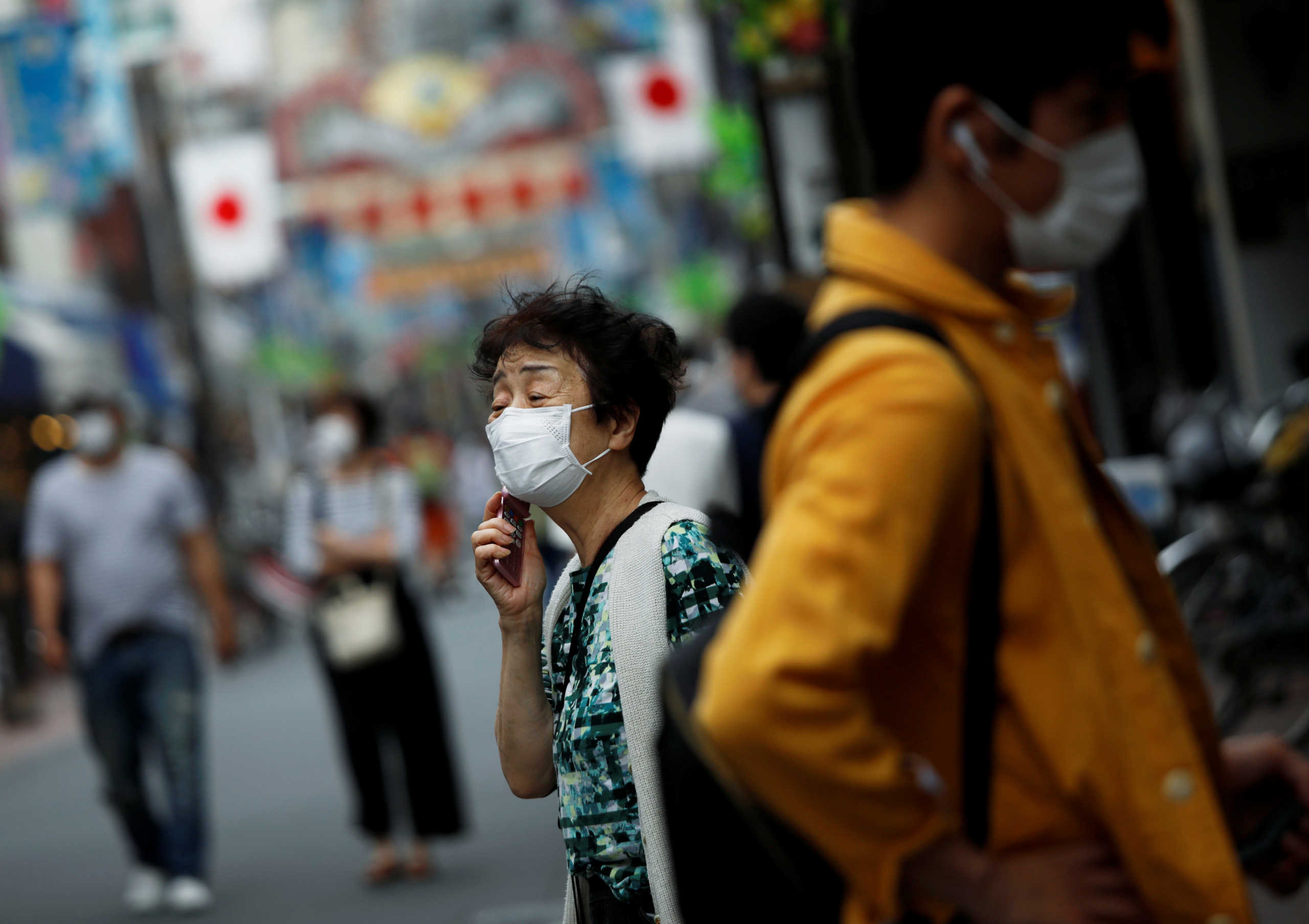 People wearing protective face masks walk on the street under a nationwide state of emergency as the spread of the coronavirus disease (COVID-19) continues in Tokyo, Japan May 10, 2020.  REUTERS