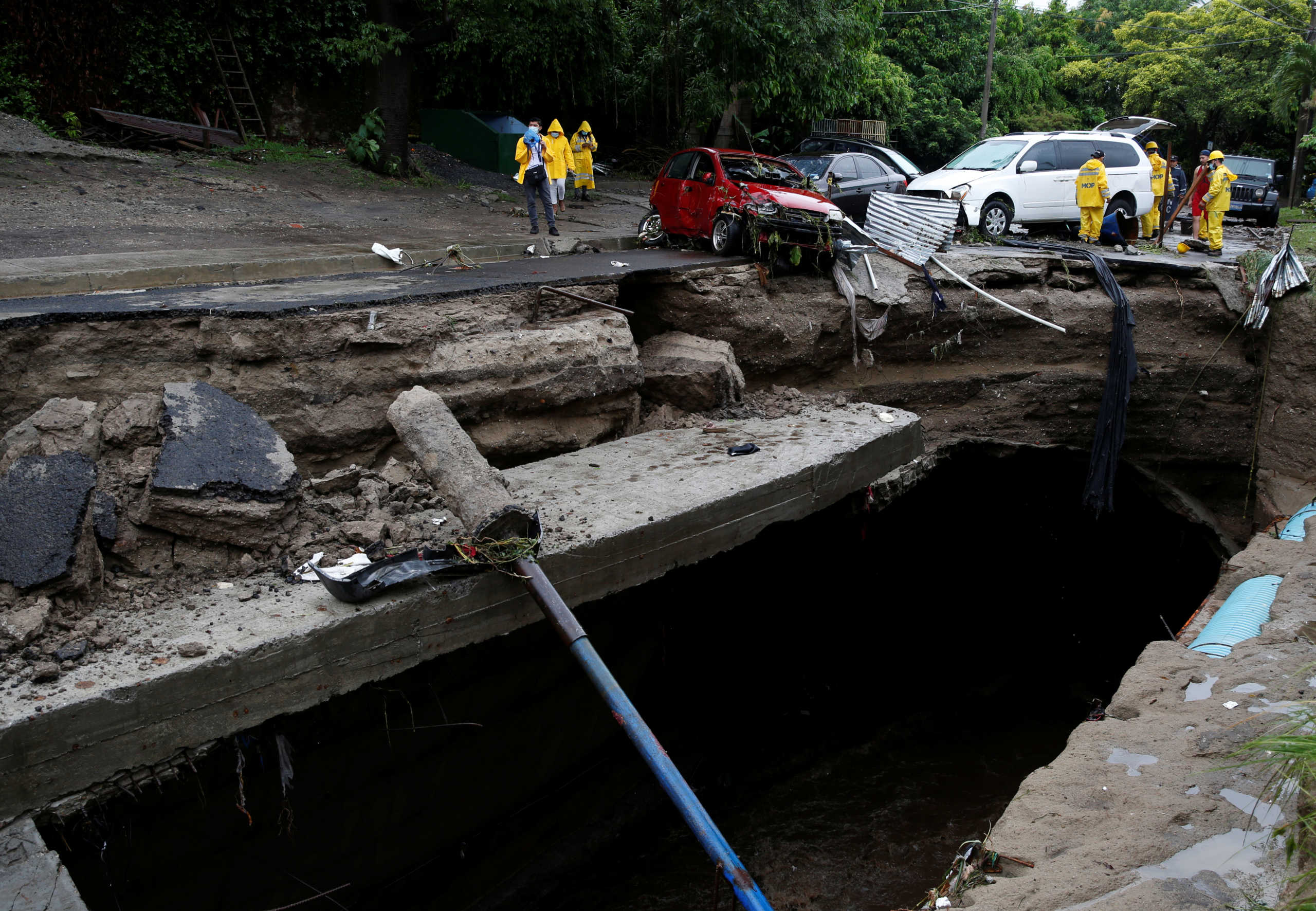 Government workers try to move cars dragged by the water during floods caused by Tropical Storm Amanda, in San Salvador, El Salvador May 31, 2020. REUTERS